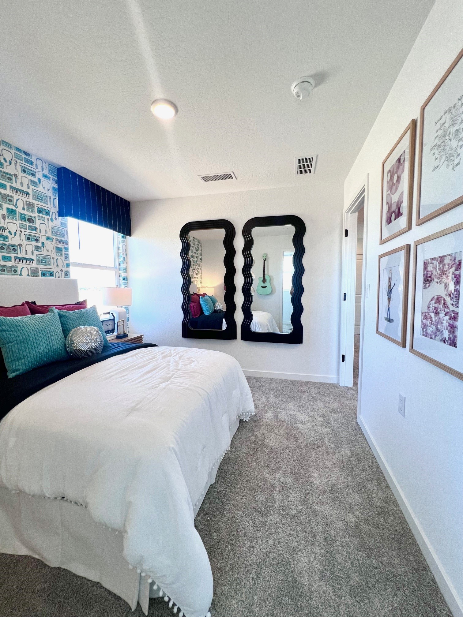 A bedroom with a mirror and a bed.