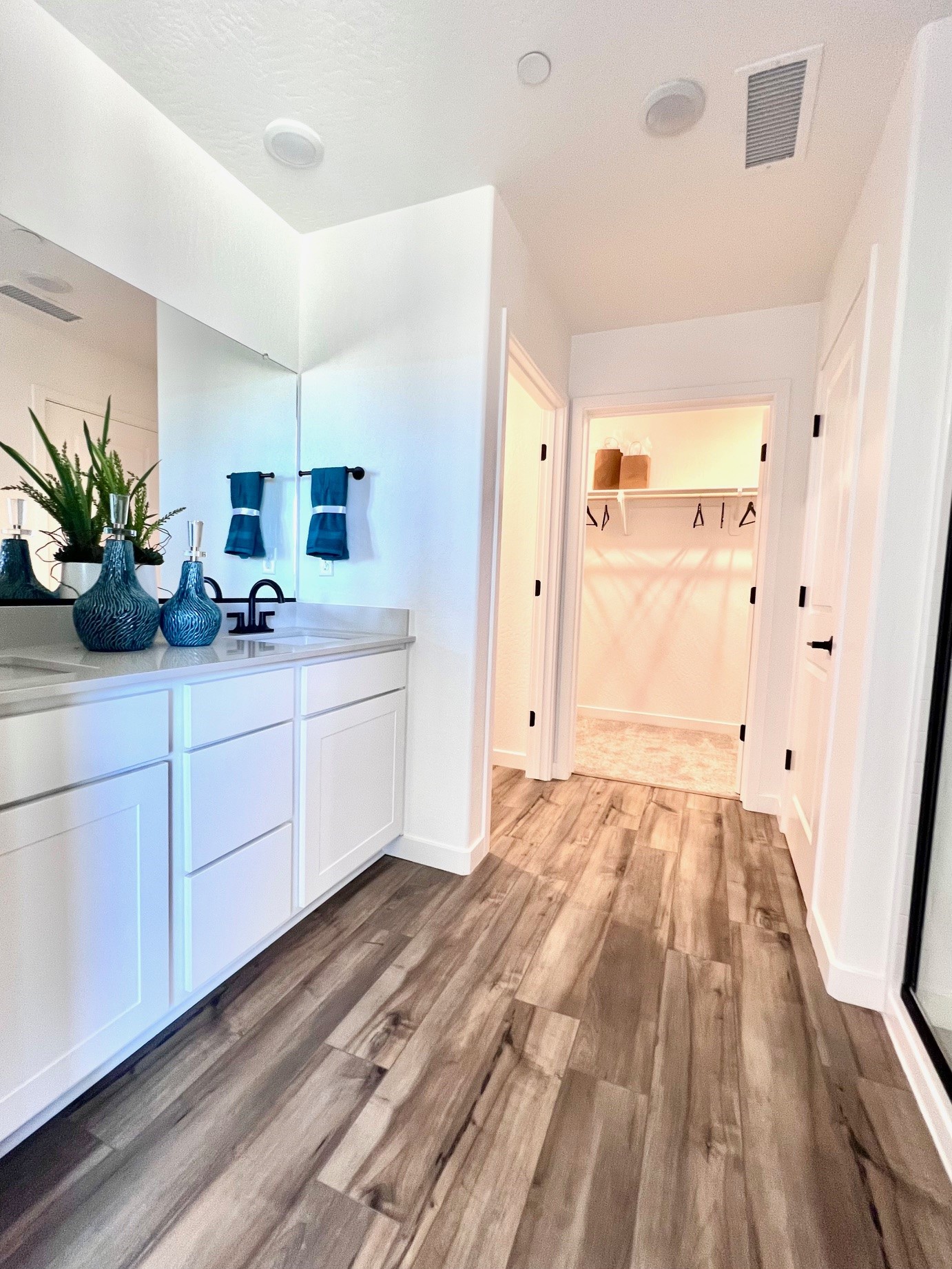 A room with white cabinets and a wood floor.