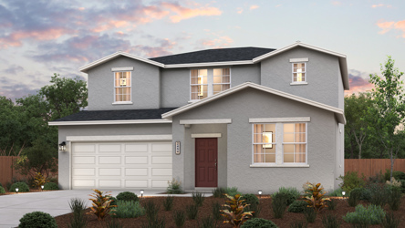 A house with a garage and bushes in front of it.