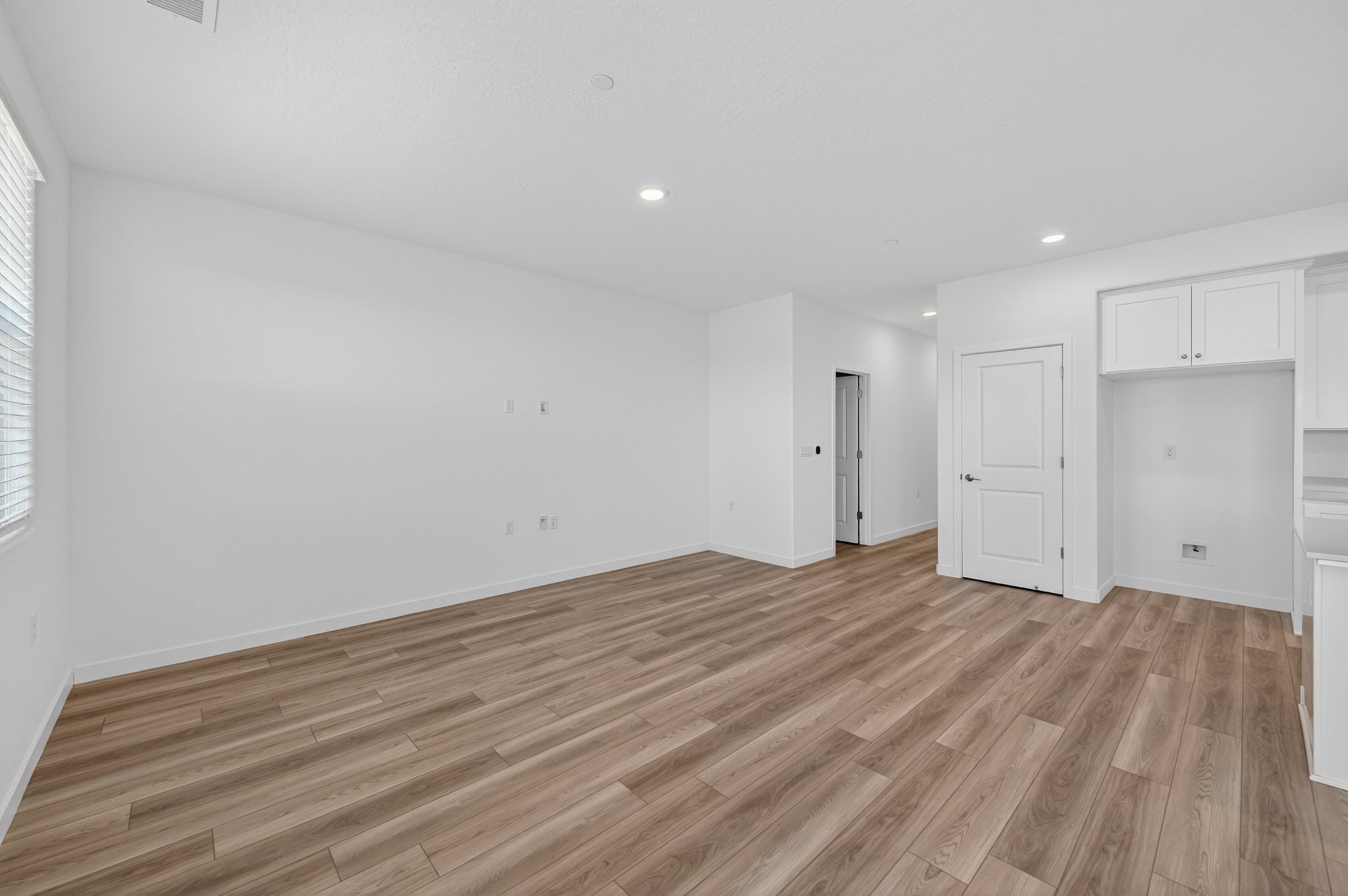 A room with white walls and wood floors.