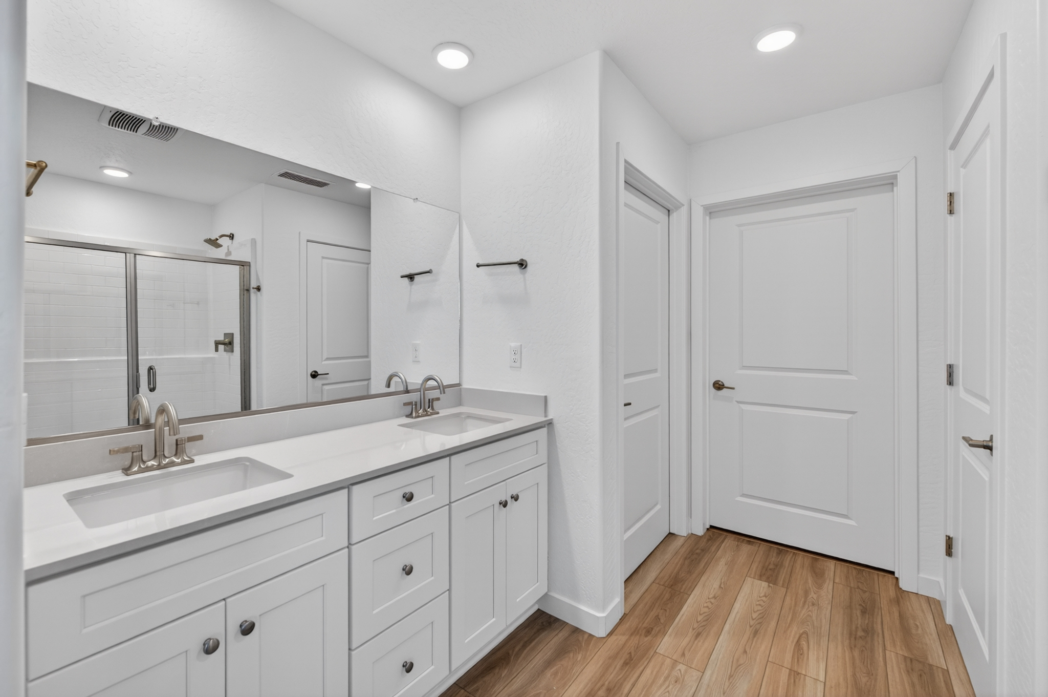 A bathroom with white cabinets.