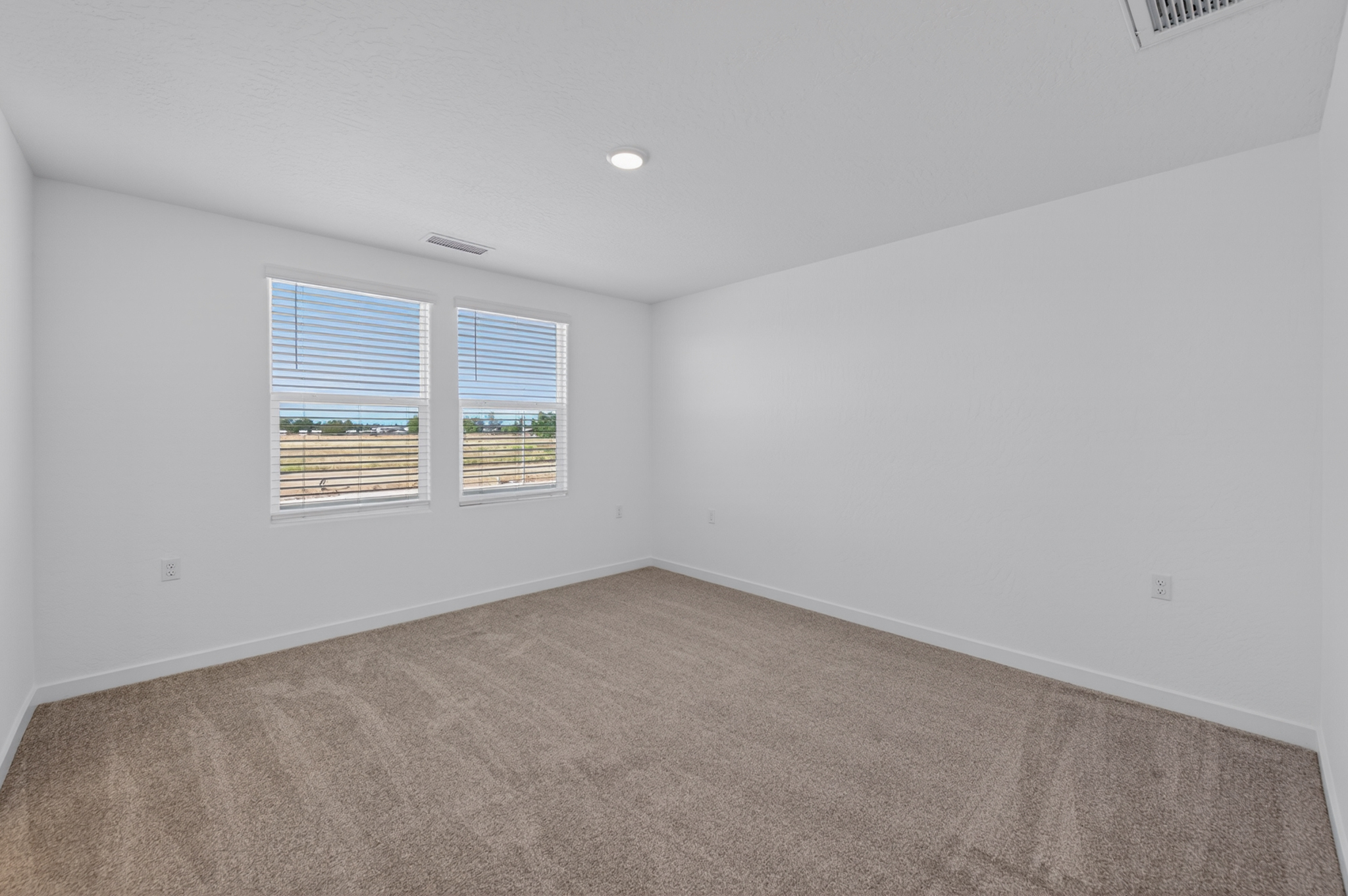 A room with a carpet and a window.