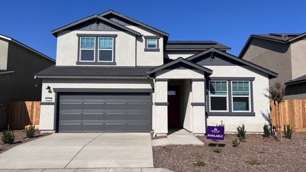 A house with garages and a brick driveway.