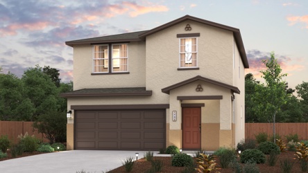 A house with a garage and trees in the back.