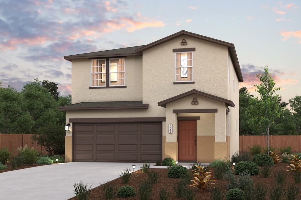 A house with a garage and trees in the back.
