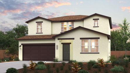 A house with a garage and bushes in front of it.