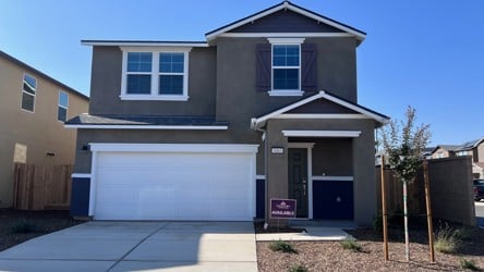 A house with garages and a sidewalk.