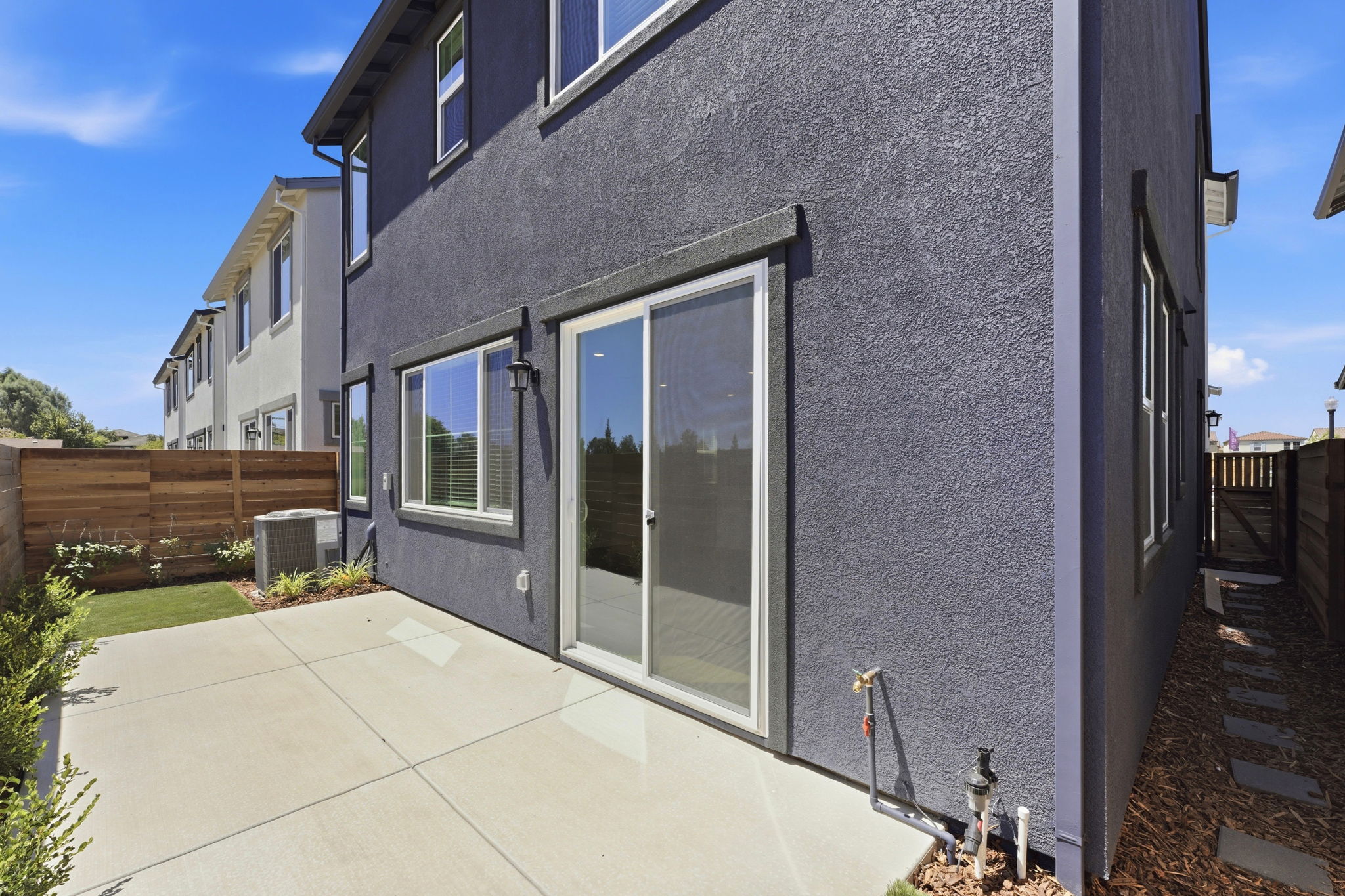 A grey house with a glass door.
