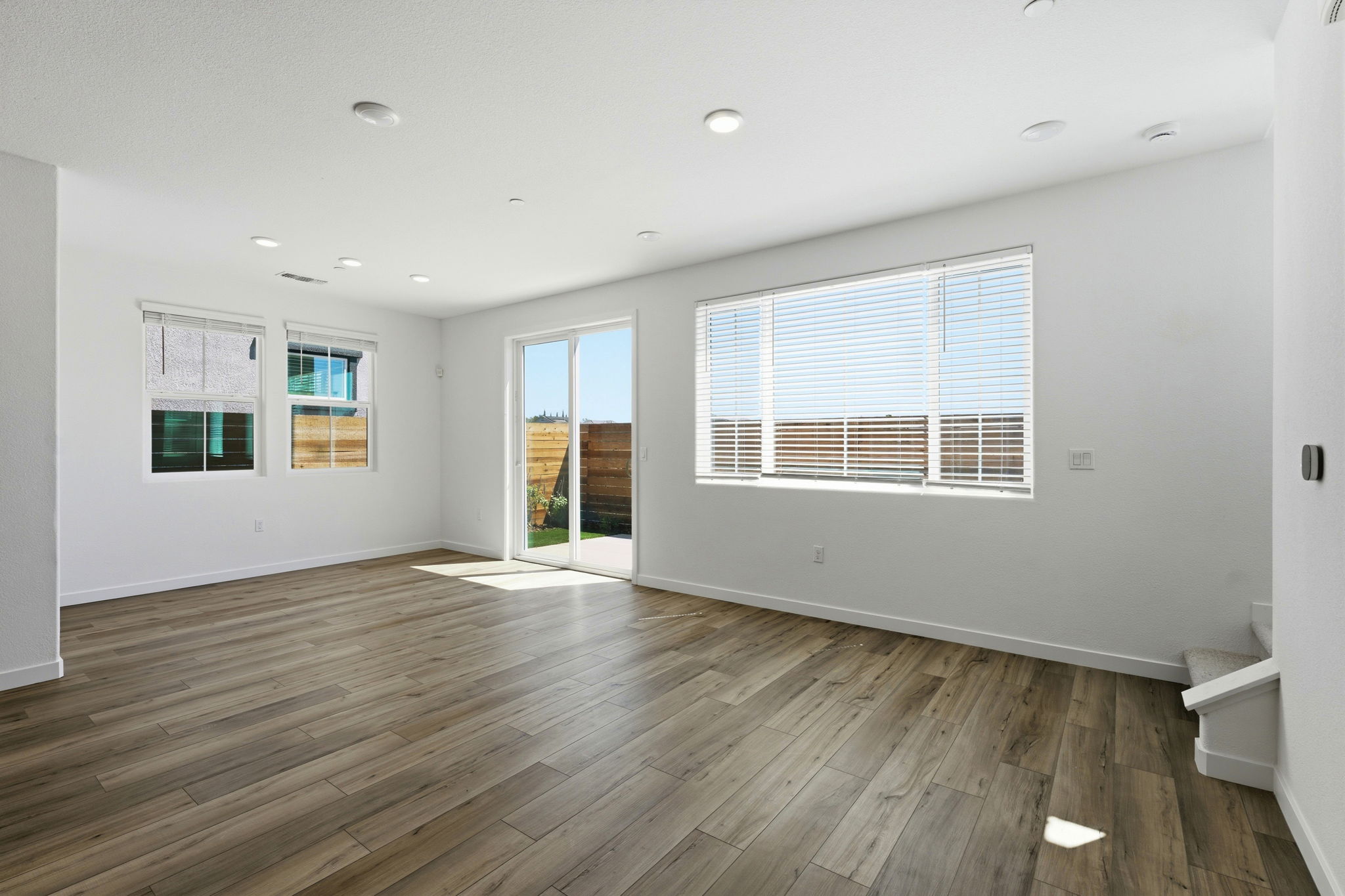 A room with a wood floor and windows.