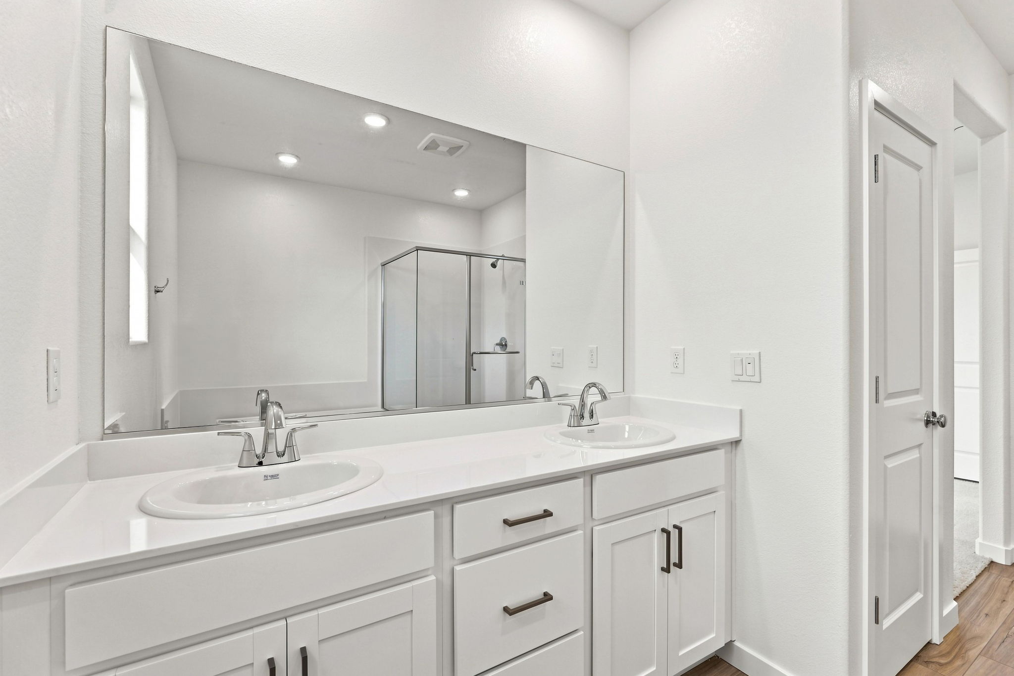A bathroom with white cabinets.