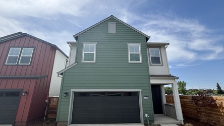 A green house with a garage.
