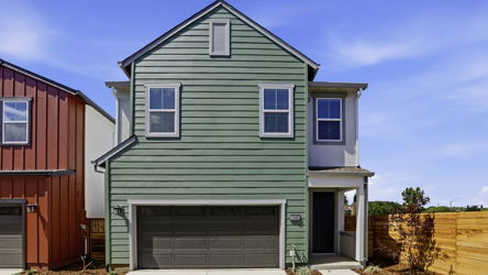 A green house with a garage.