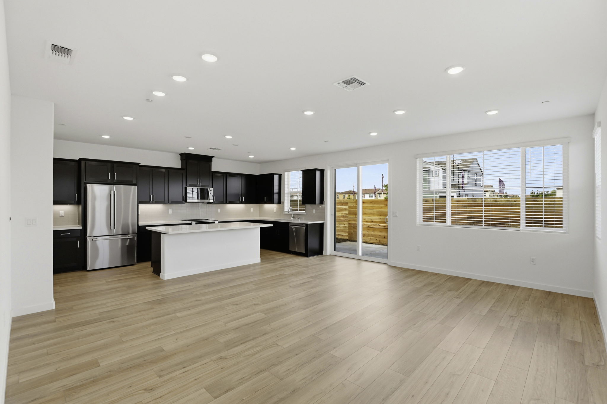 A large kitchen with black appliances.
