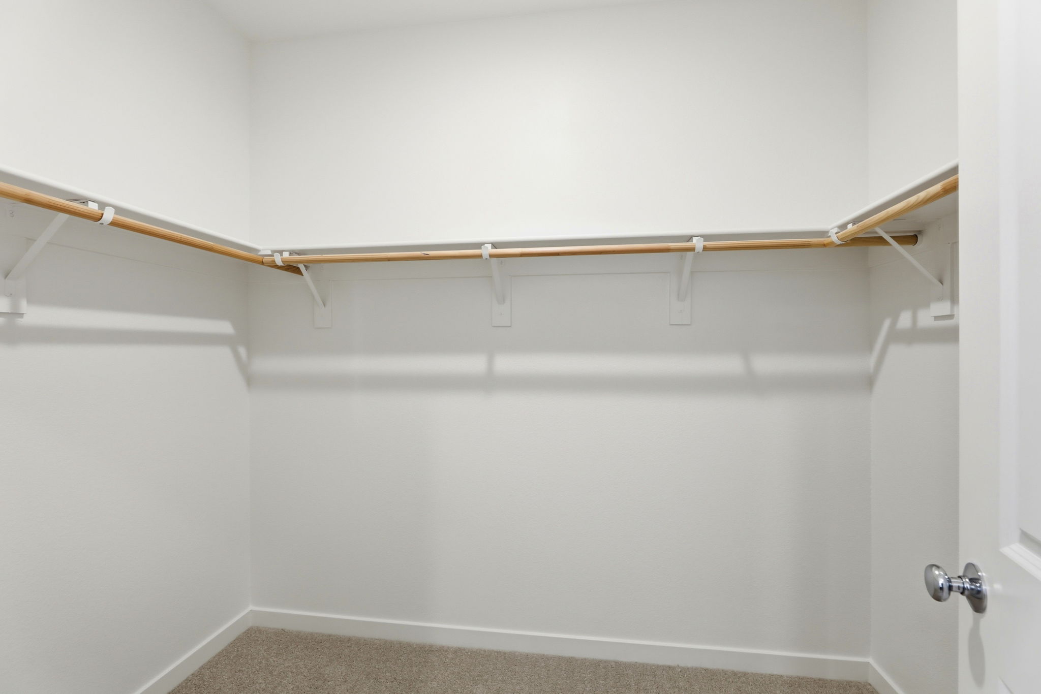 A white wall with a metal bar.
