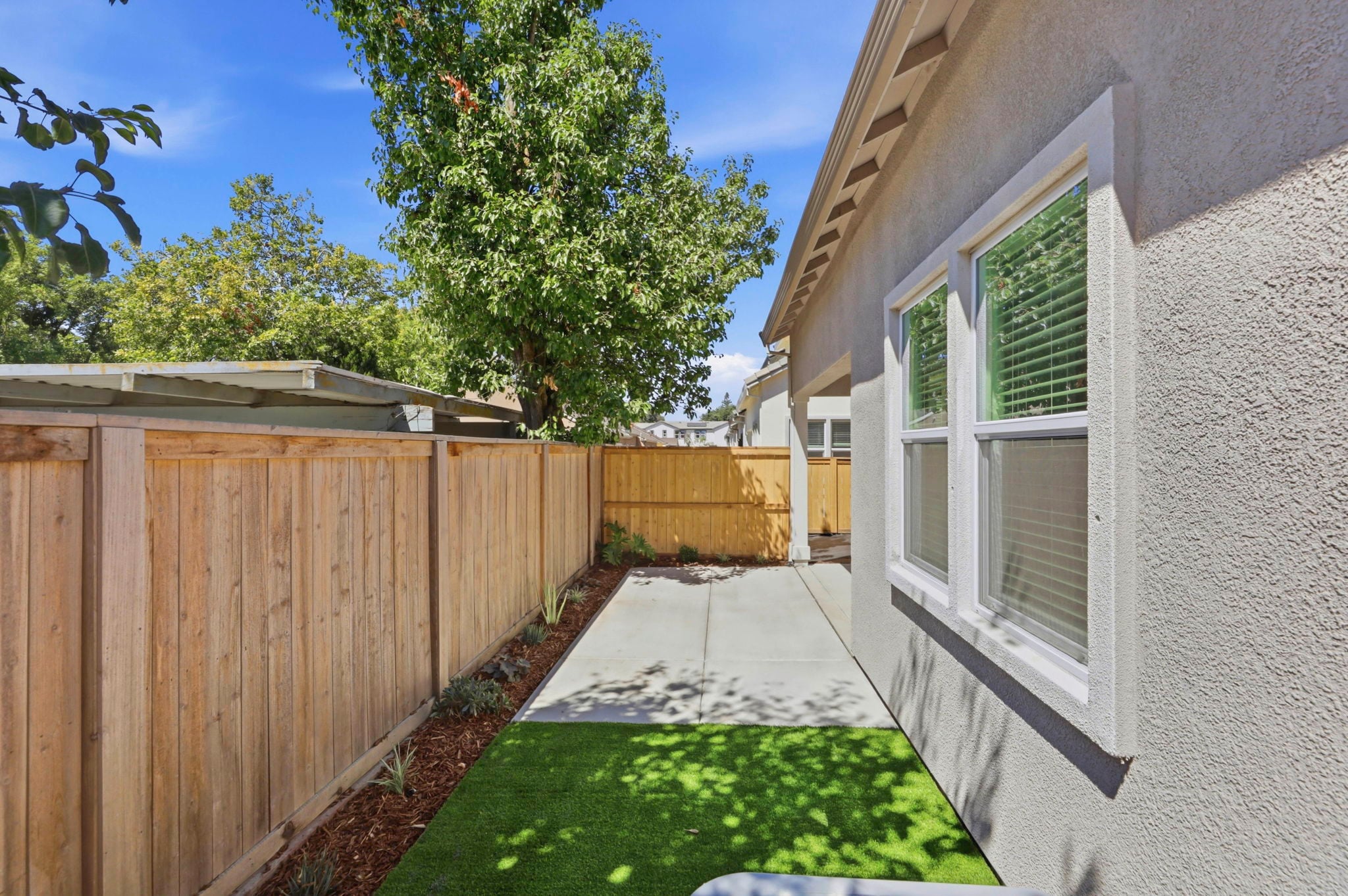 A fenced in yard with a house and trees.