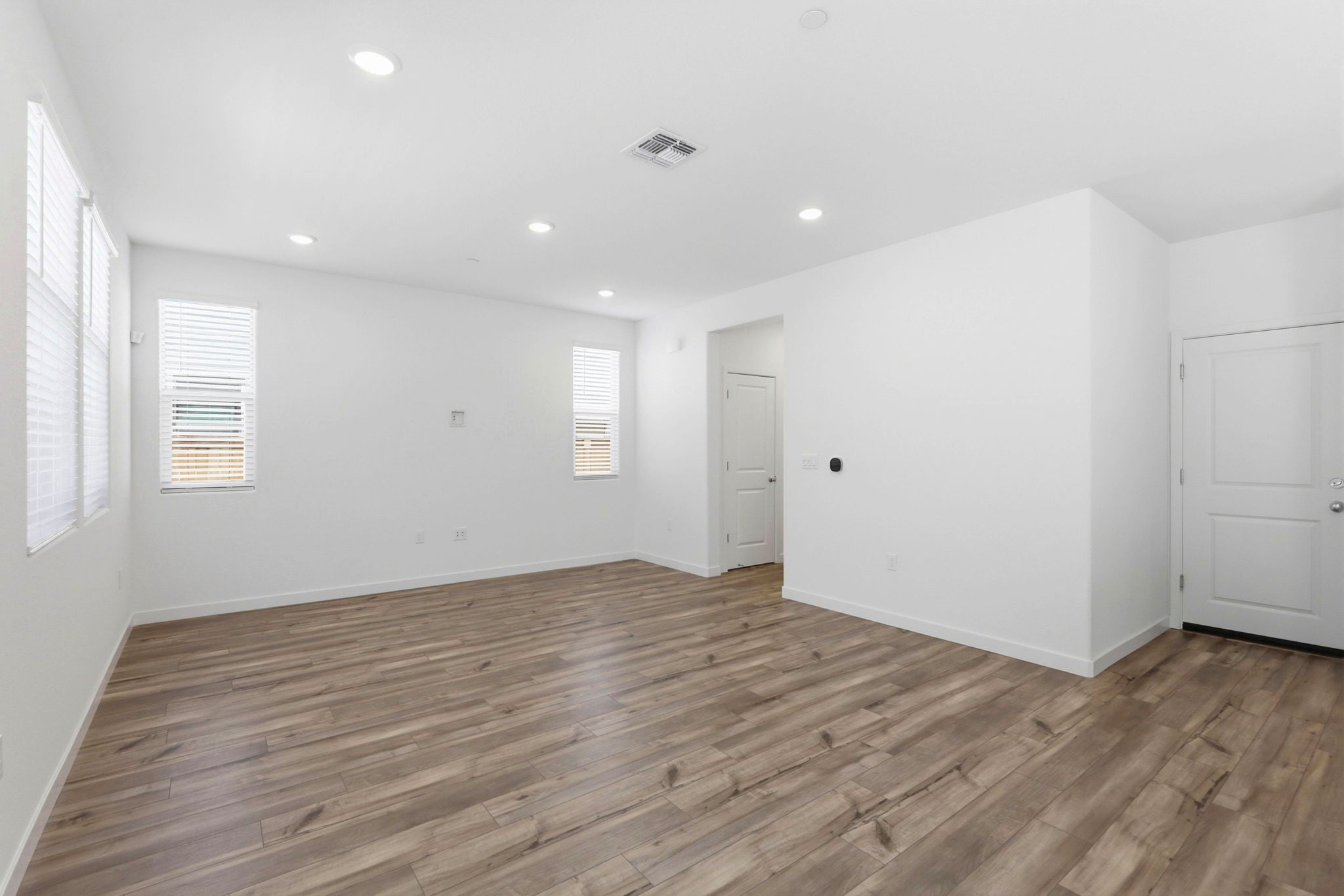 A room with white walls and wood floors.