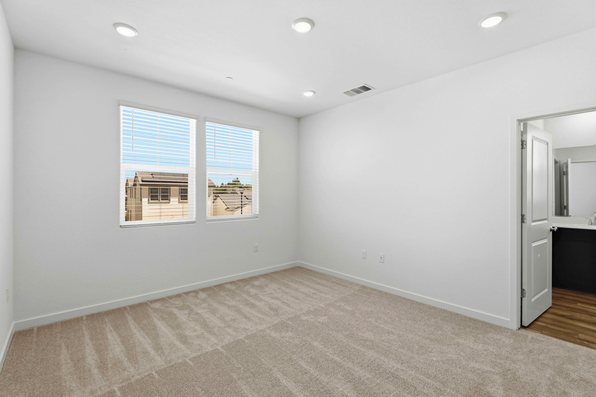 A room with a carpet and windows.