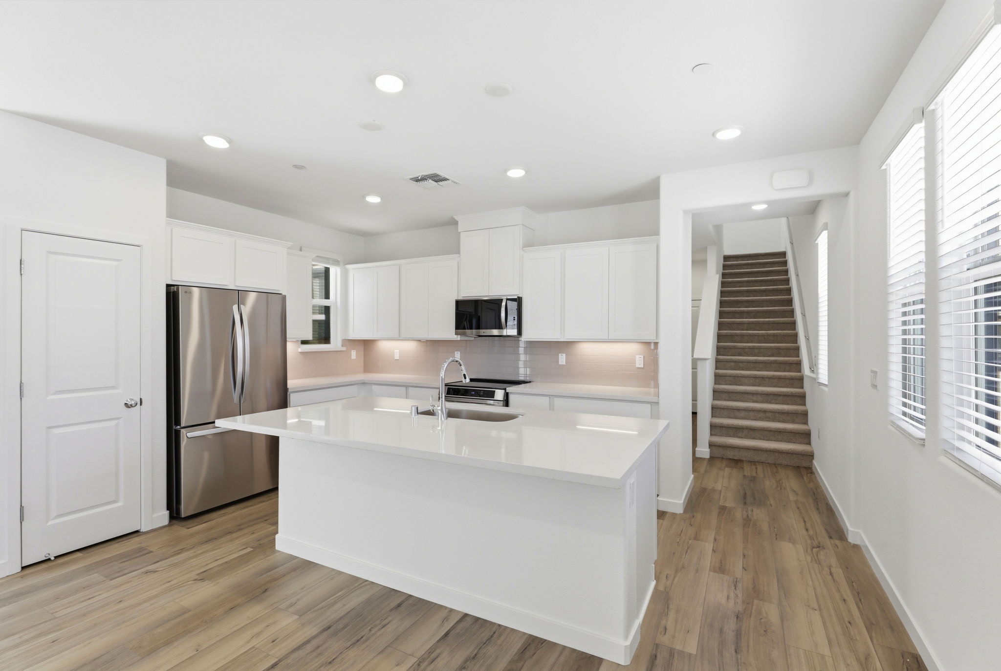 A kitchen with white cabinets.