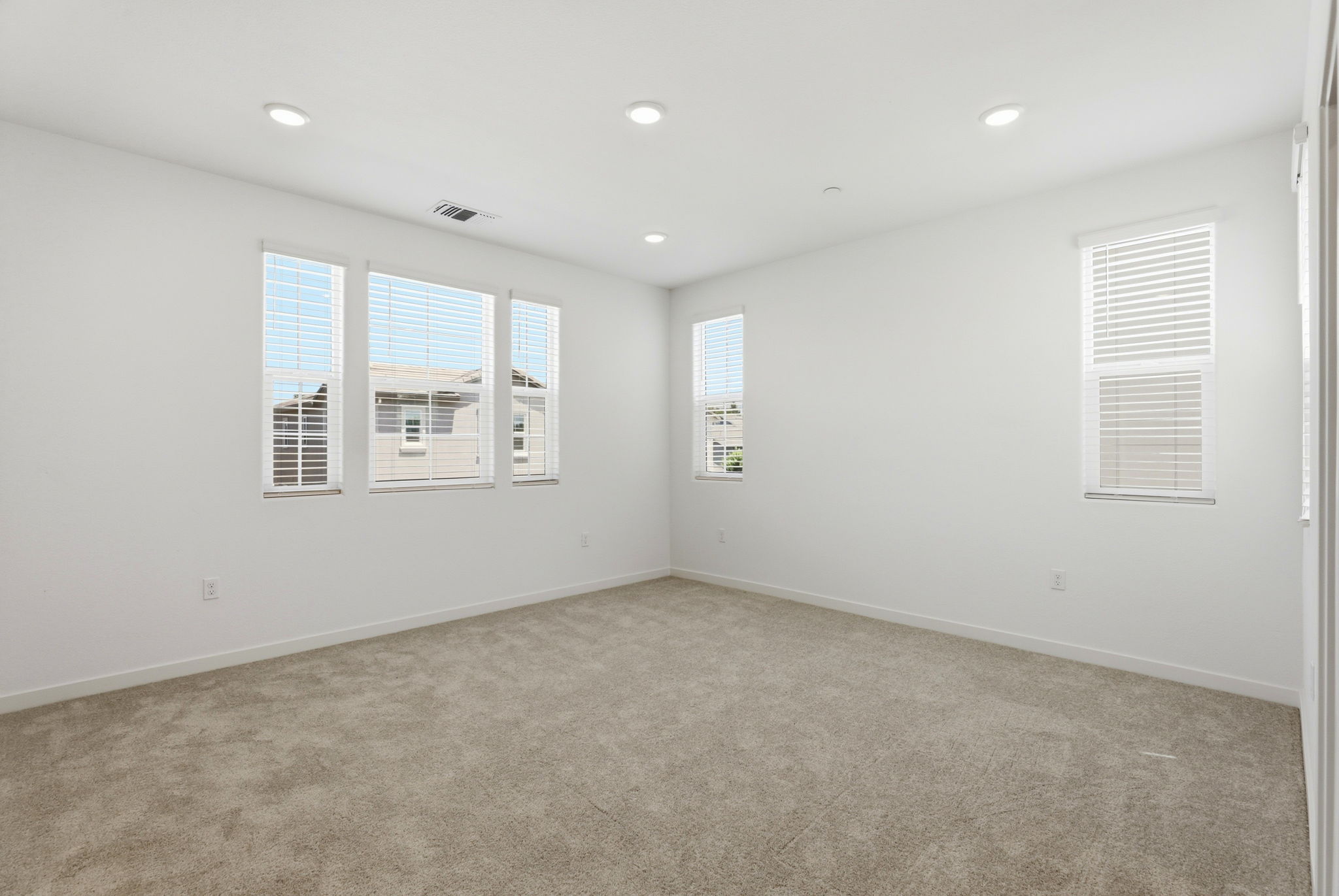 A room with a carpet and windows.