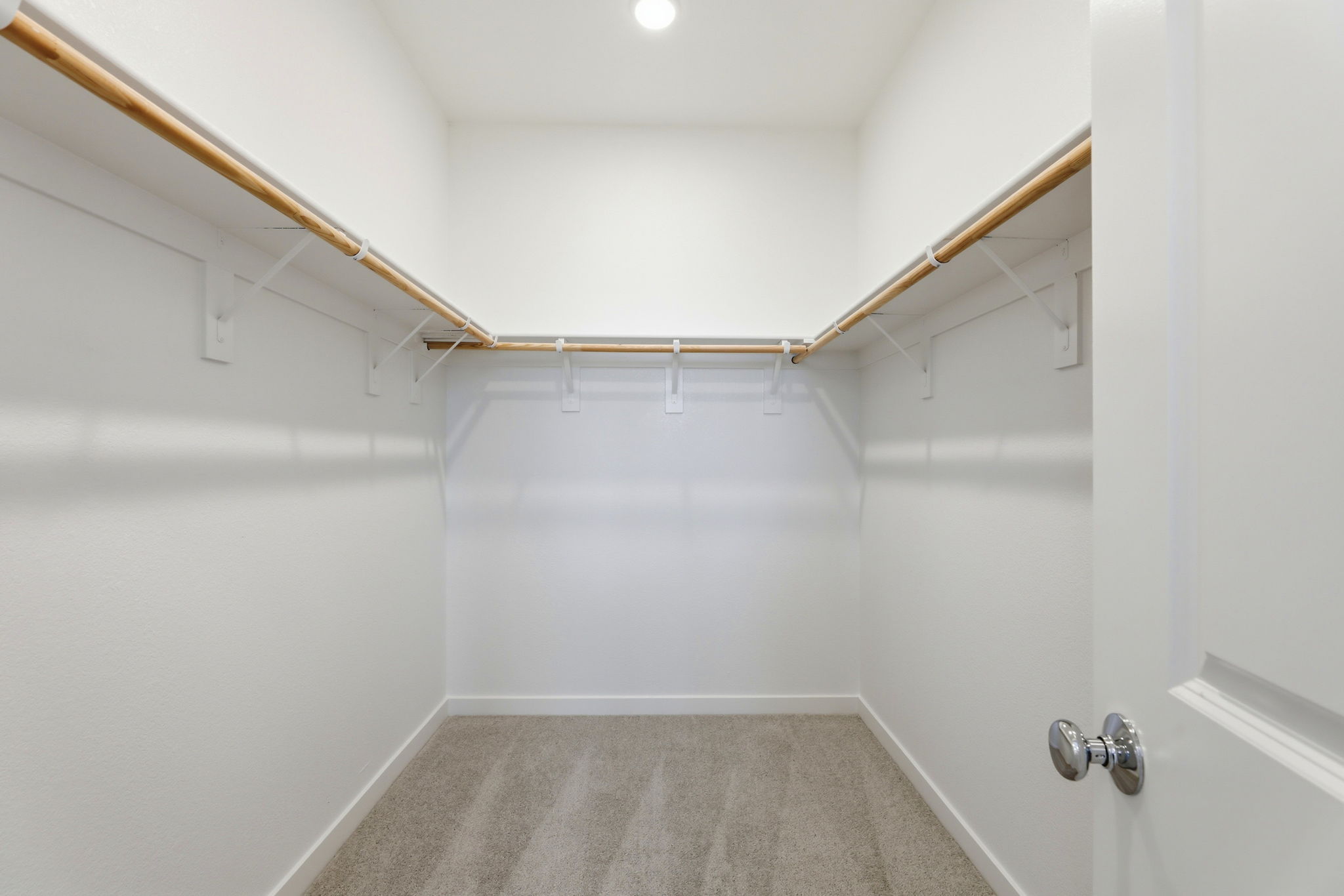 A white bathroom with a metal bar.