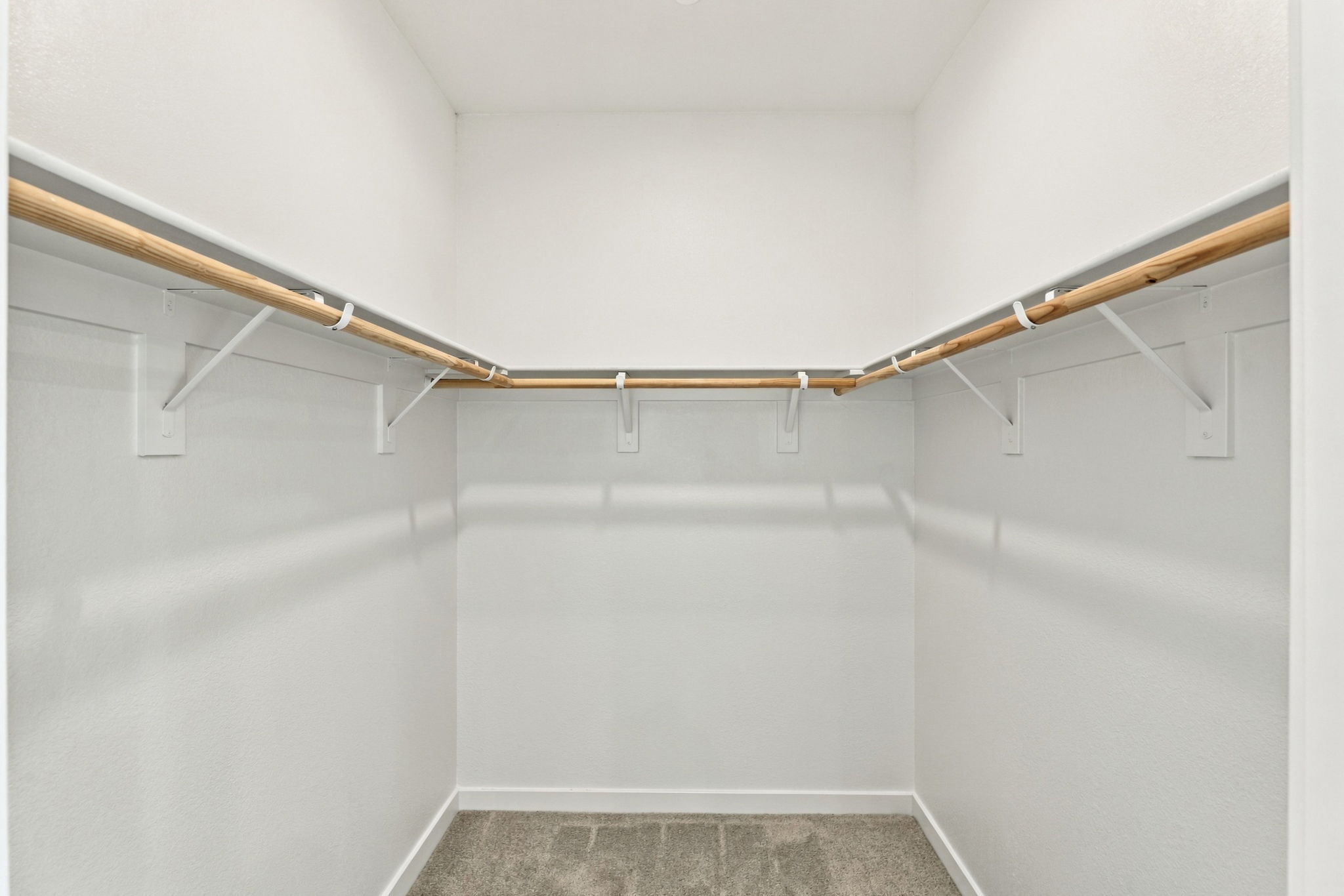 A white wall with a metal bar.