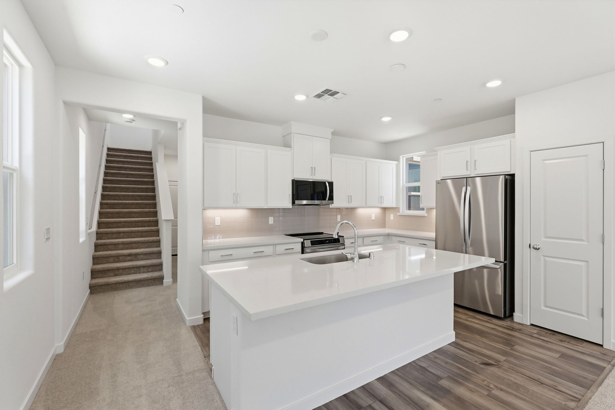 A kitchen with white cabinets.