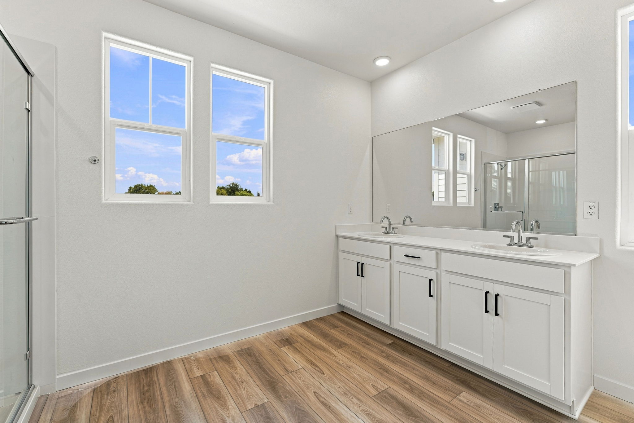 A bathroom with white cabinets.