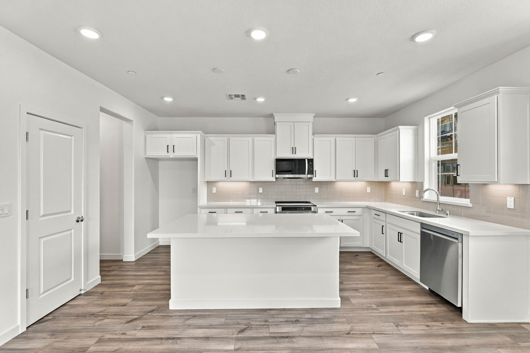 A kitchen with white cabinets.