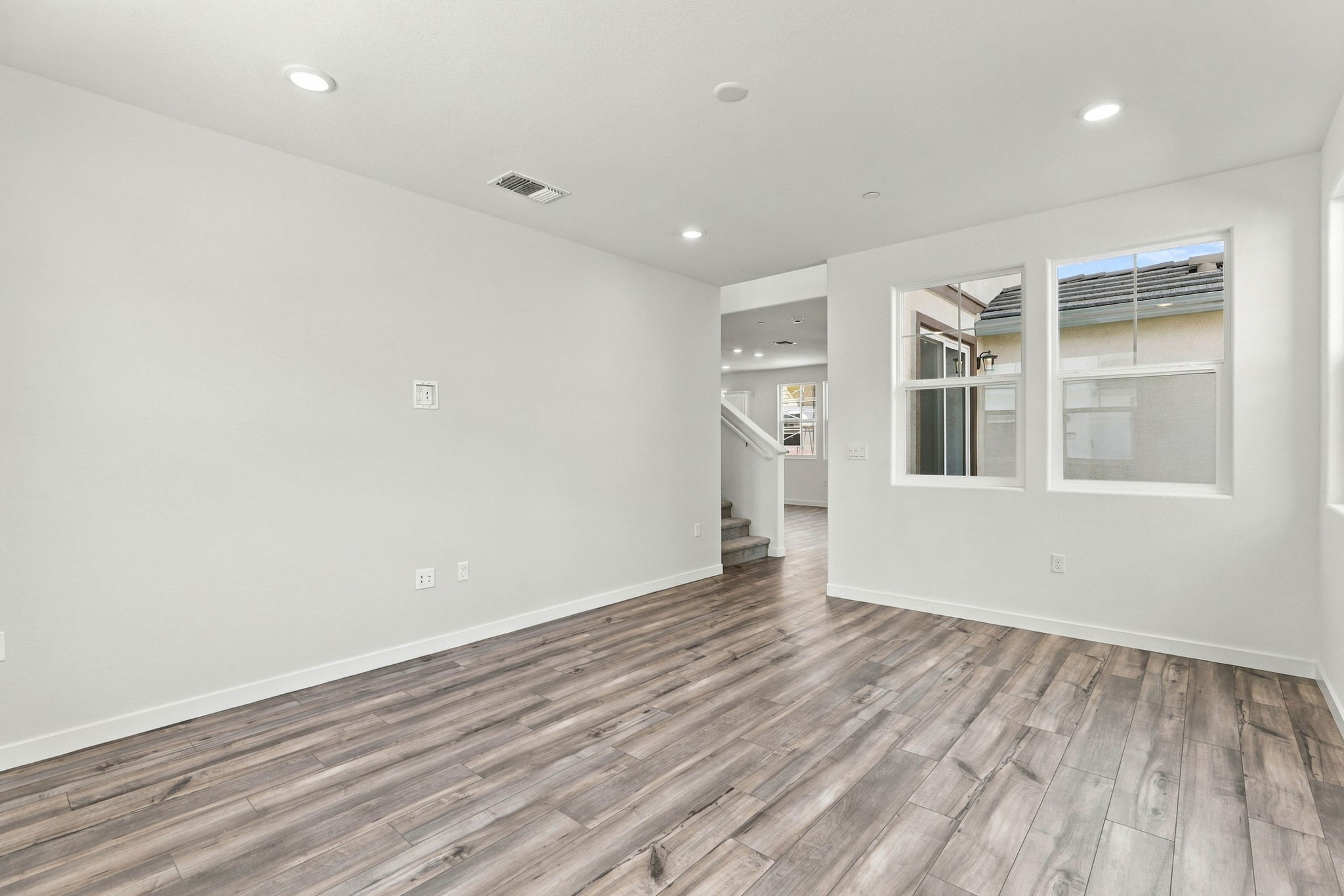 A room with a wood floor and white walls.