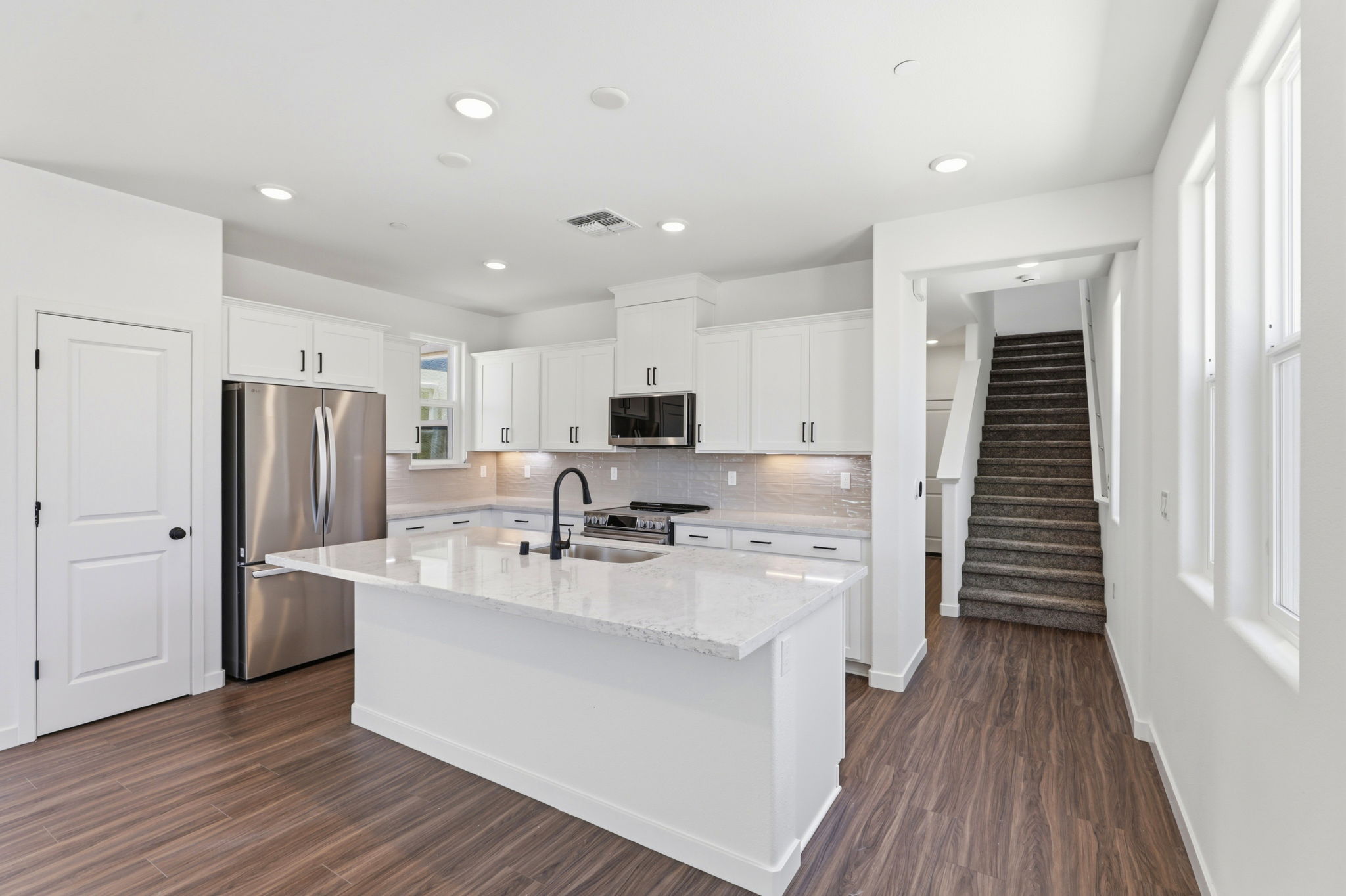 A kitchen with white cabinets.