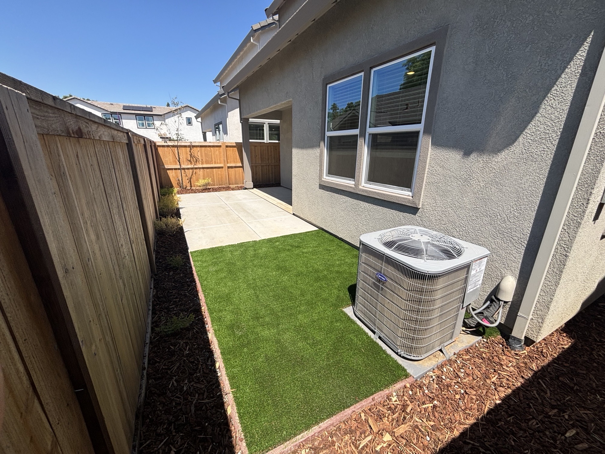 A backyard with a grill and a large metal grill.