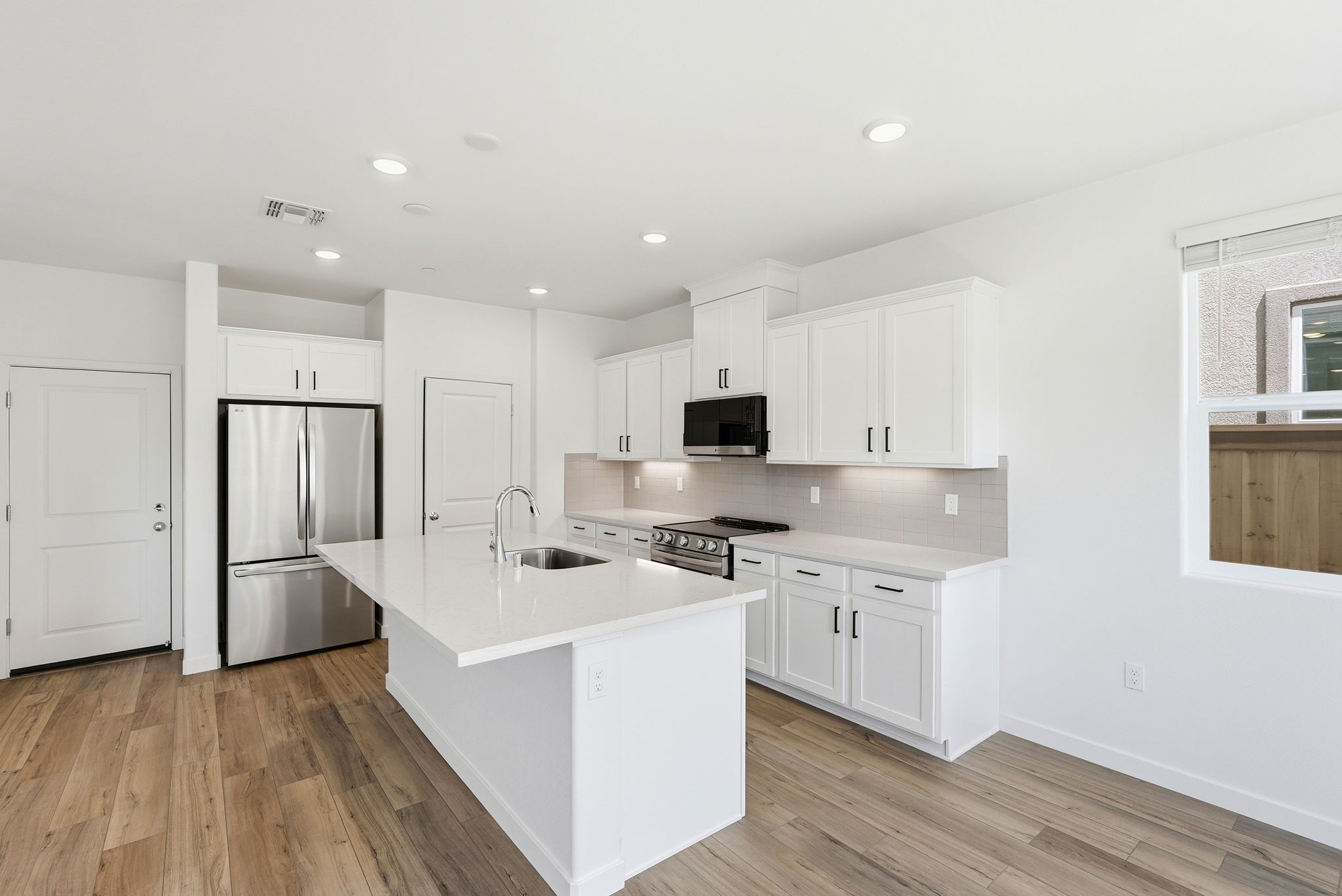 A kitchen with white cabinets.