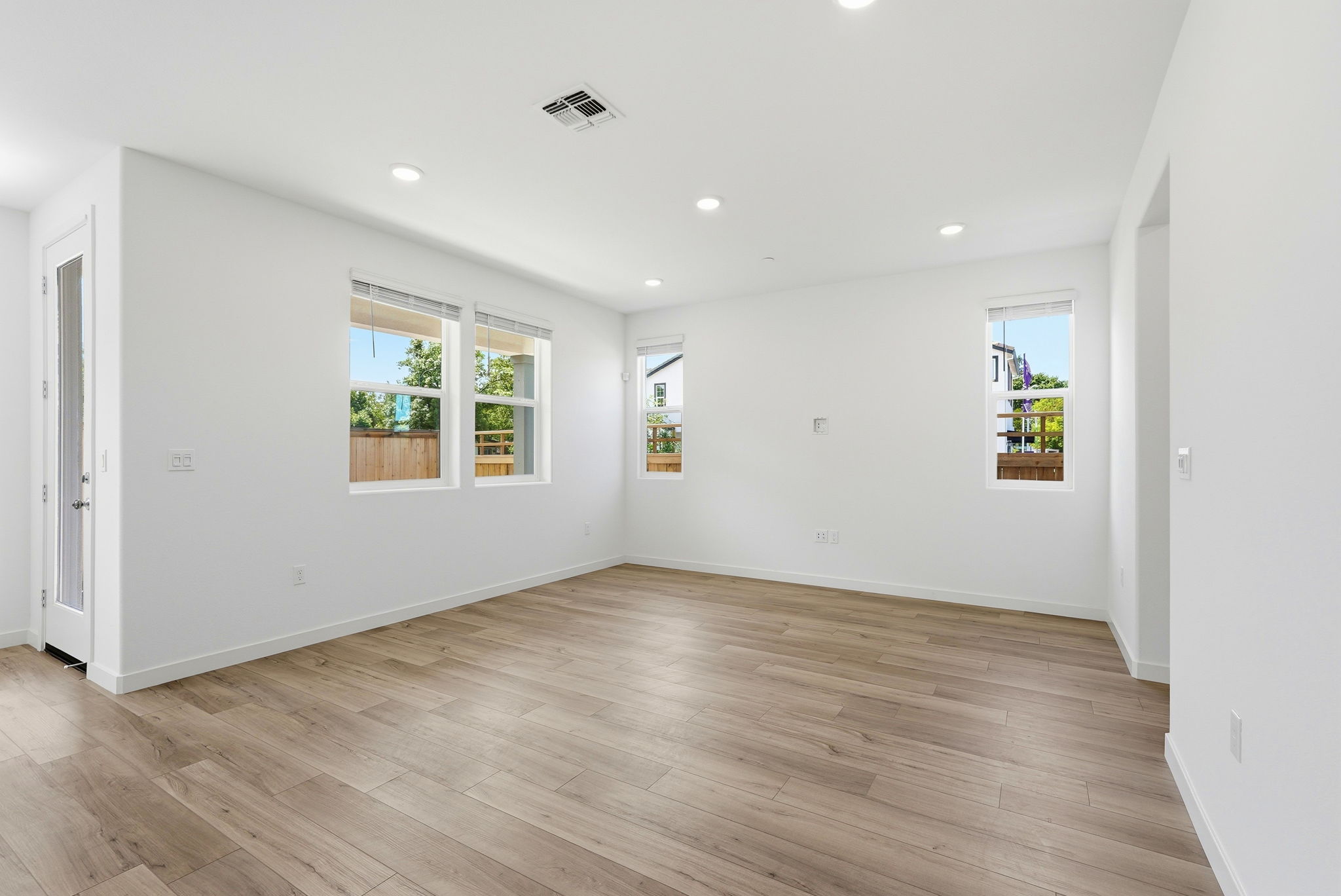 A room with a wood floor and windows.
