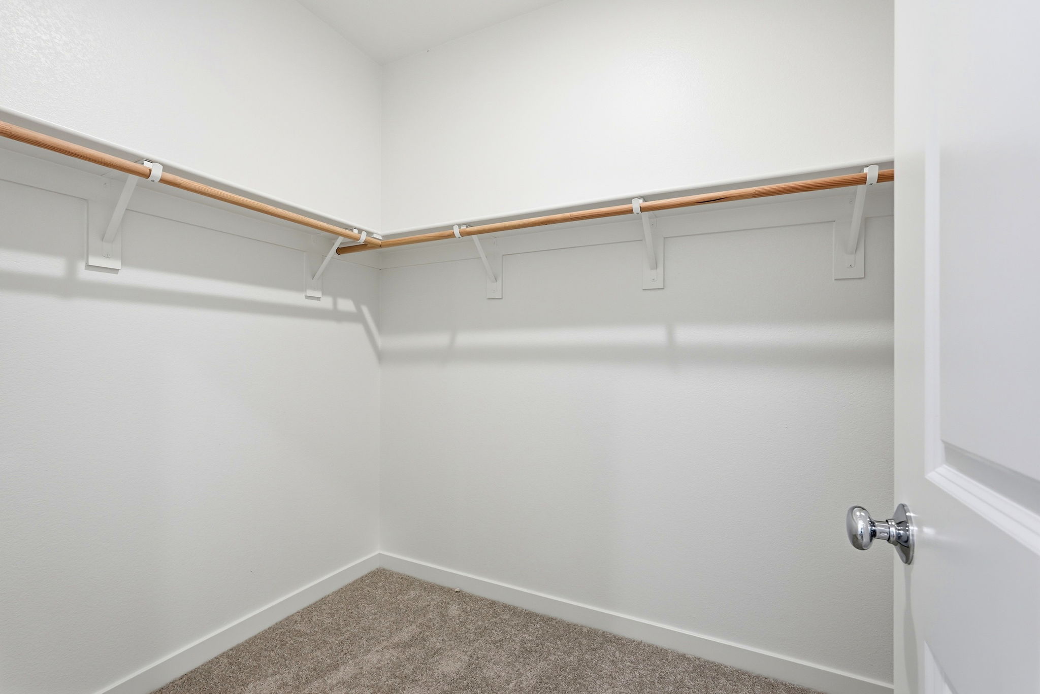 A white wall with a metal bar.