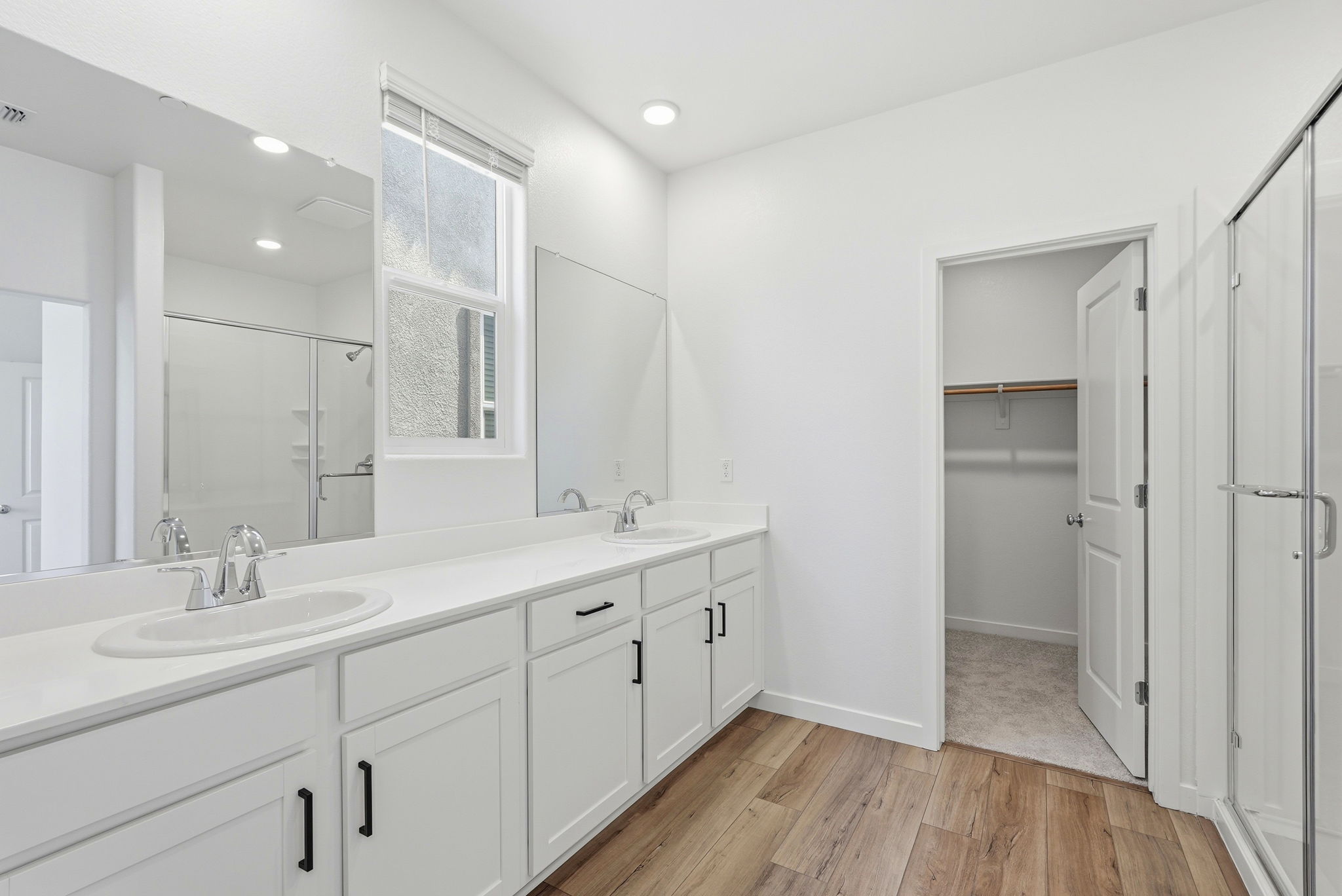 A bathroom with white cabinets.