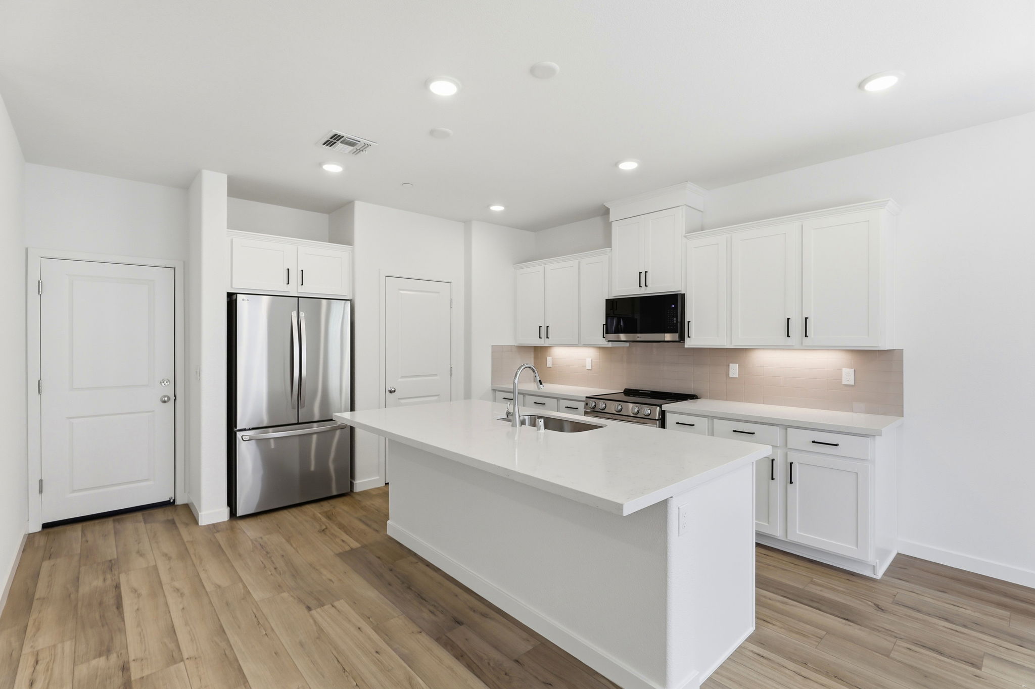 A kitchen with white cabinets.