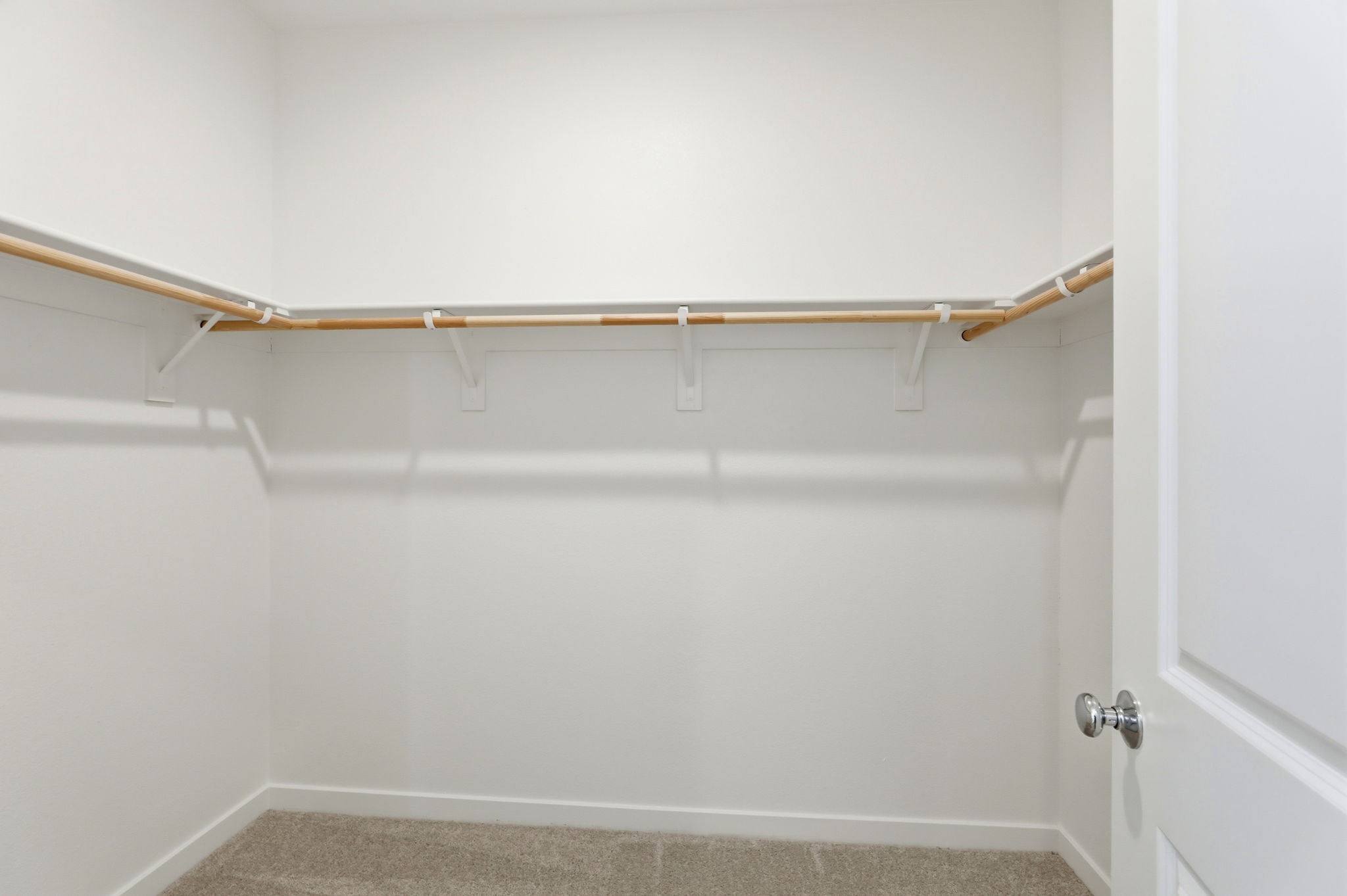 A white wall with a metal bar.