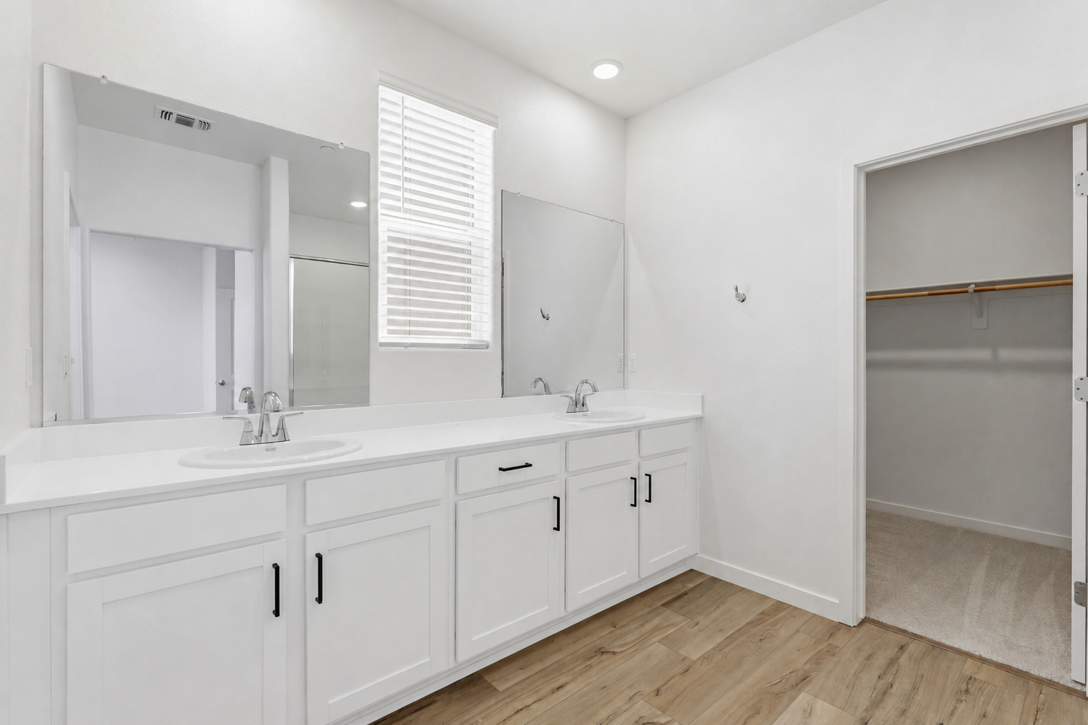A bathroom with white cabinets.