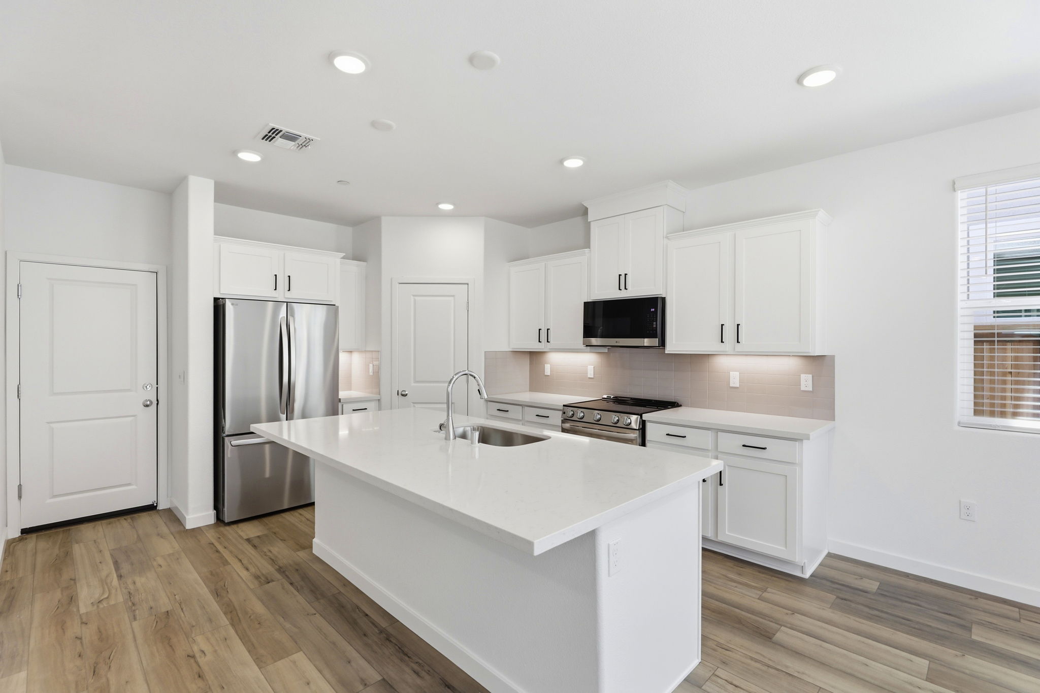 A kitchen with white cabinets.