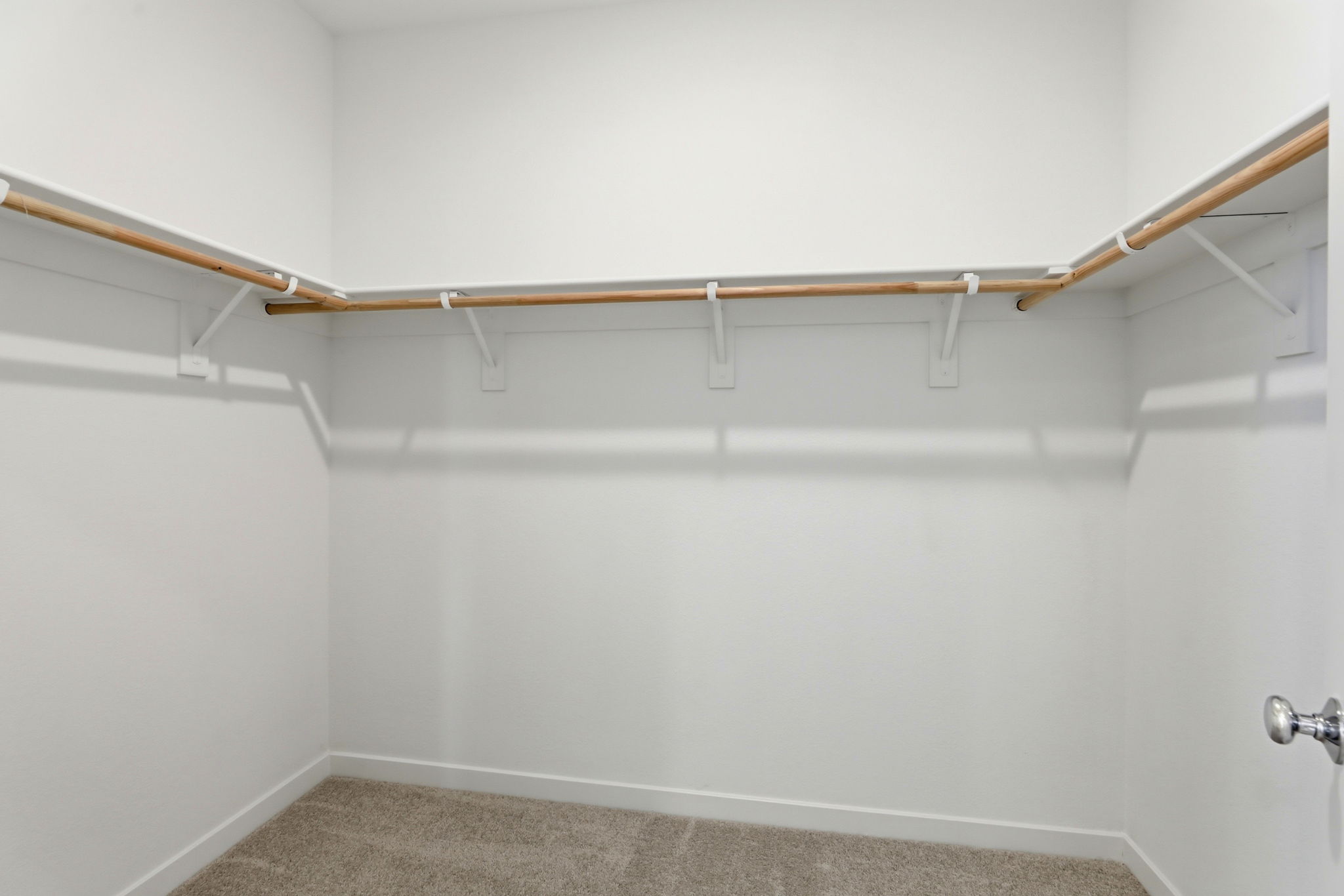 A white wall with a metal bar.