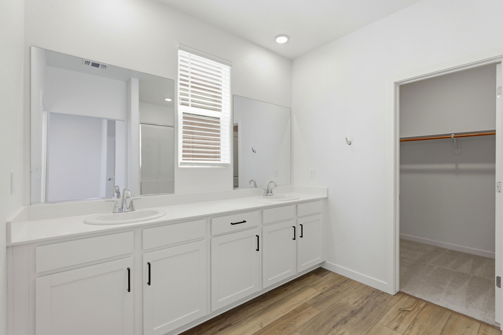 A bathroom with white cabinets.