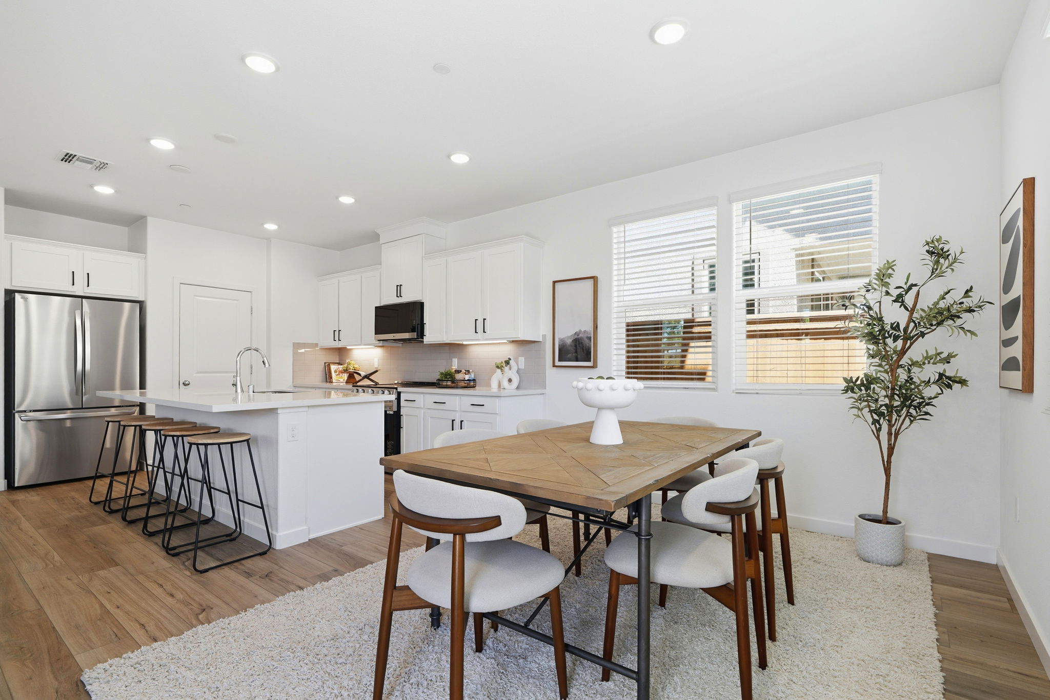 A kitchen with a dining table and chairs.
