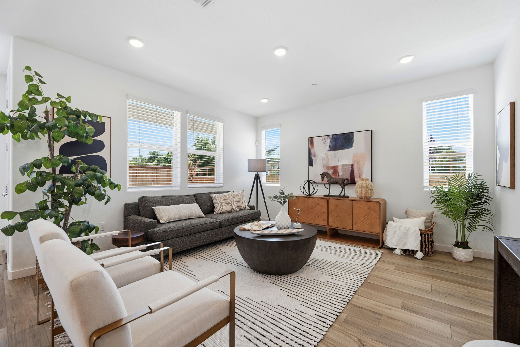 A living room with a large rug and a large round table.