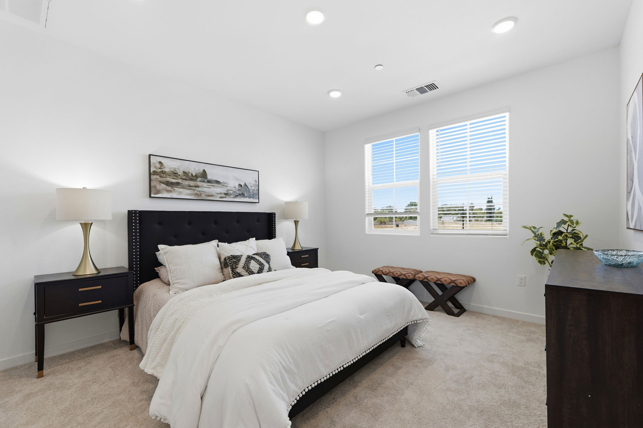 A bedroom with a bed and a bench.