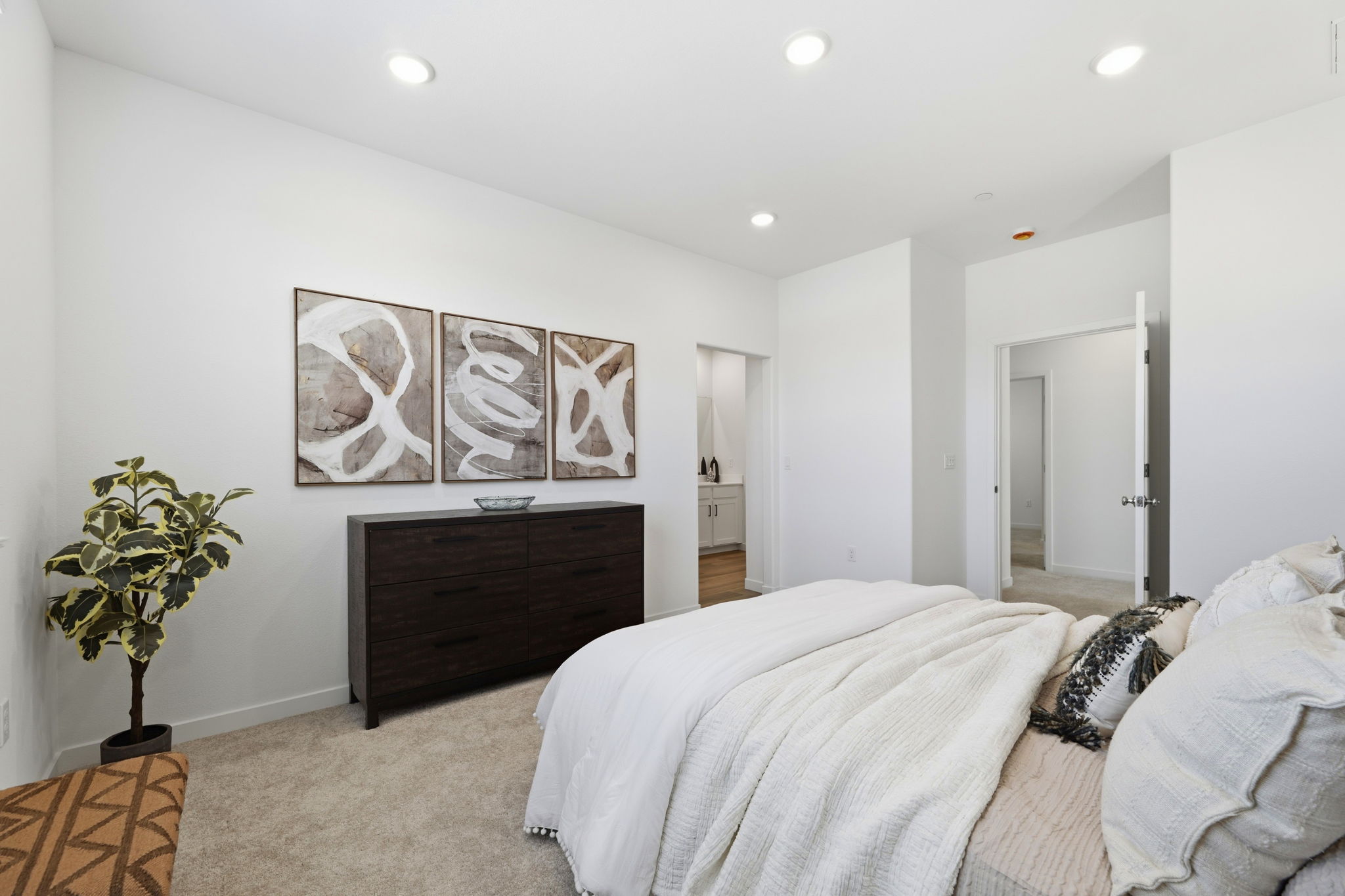A bedroom with a bed and a plant.
