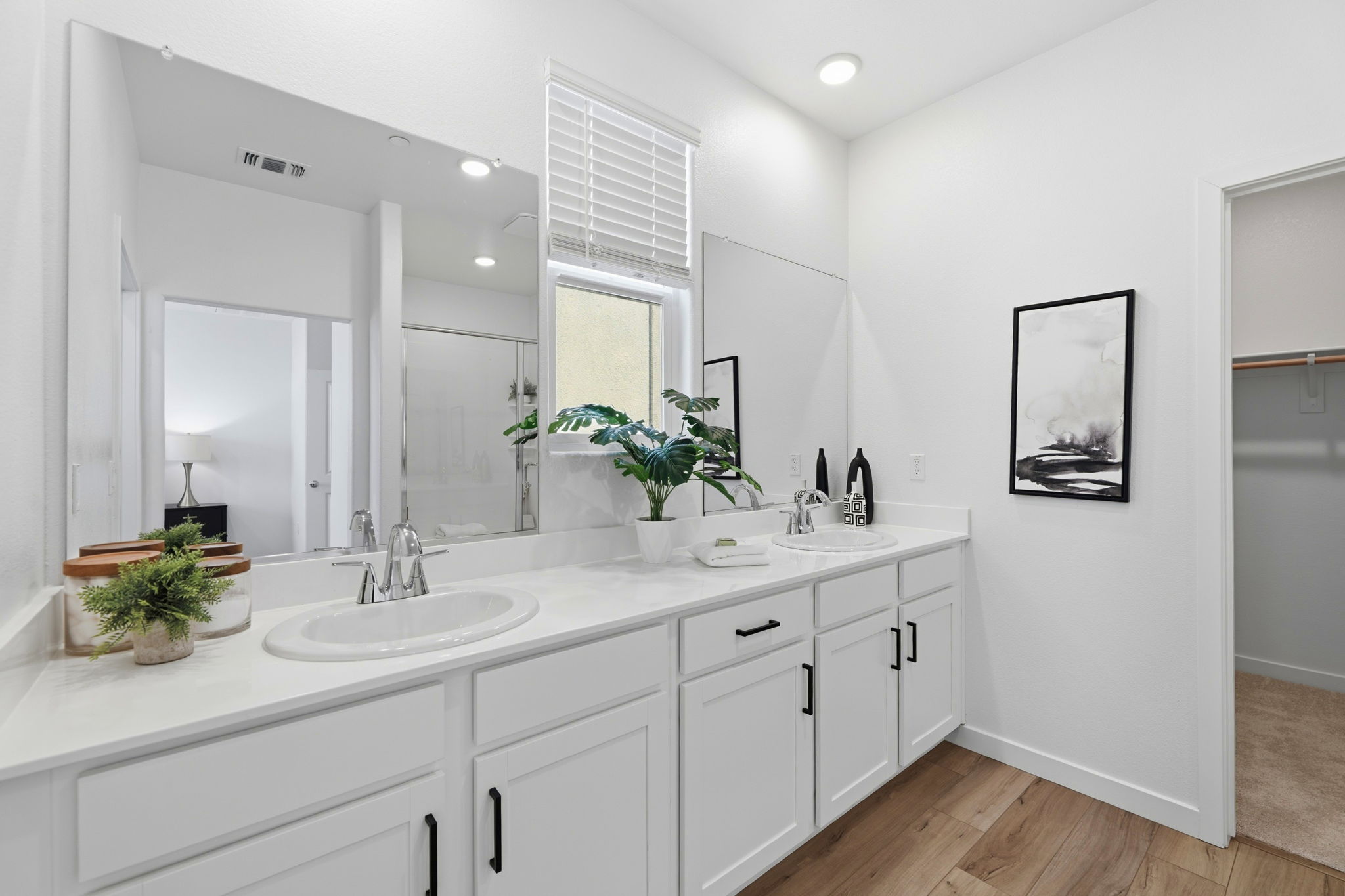A bathroom with white cabinets.