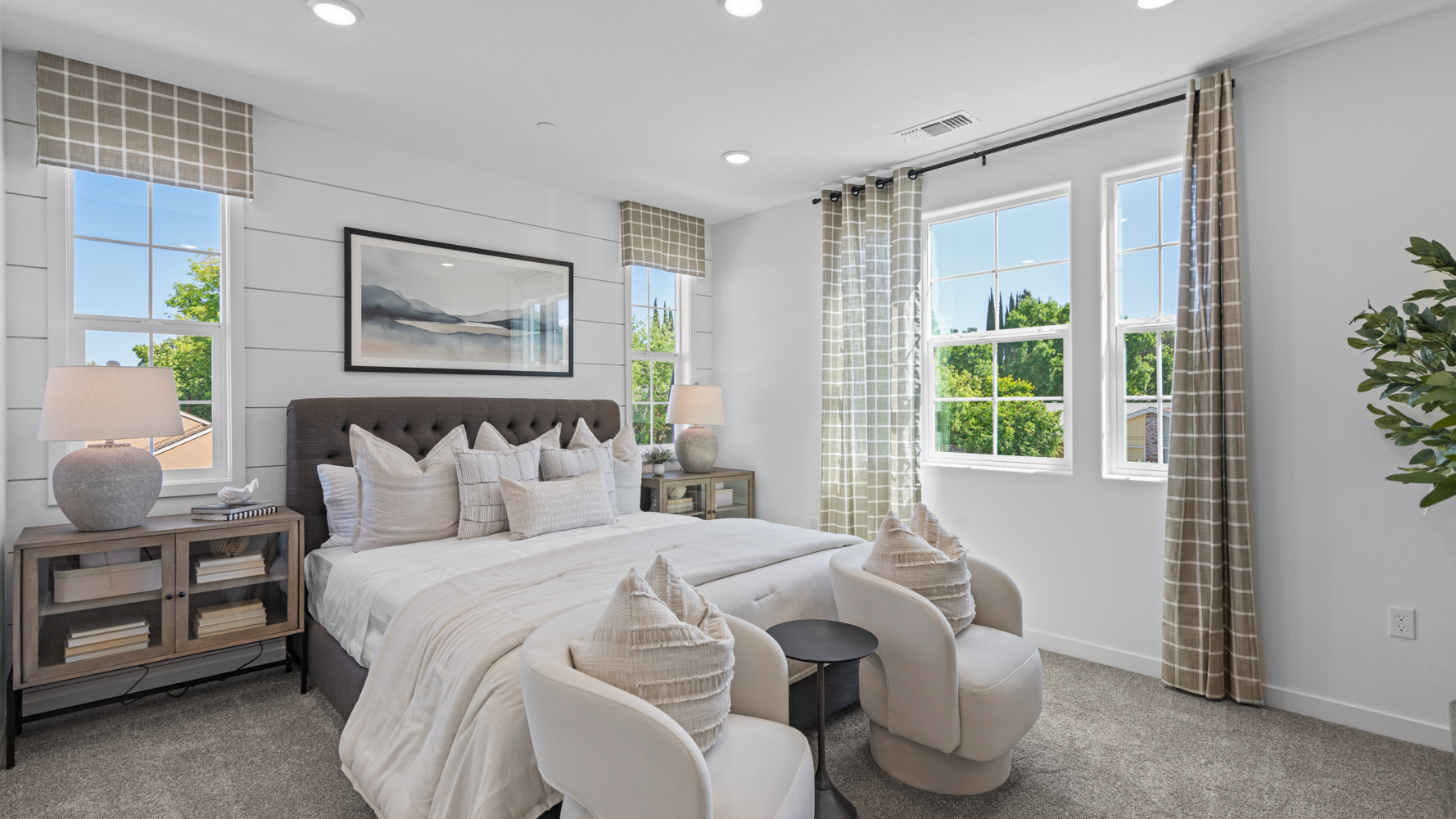 A bedroom with a bed and chairs.