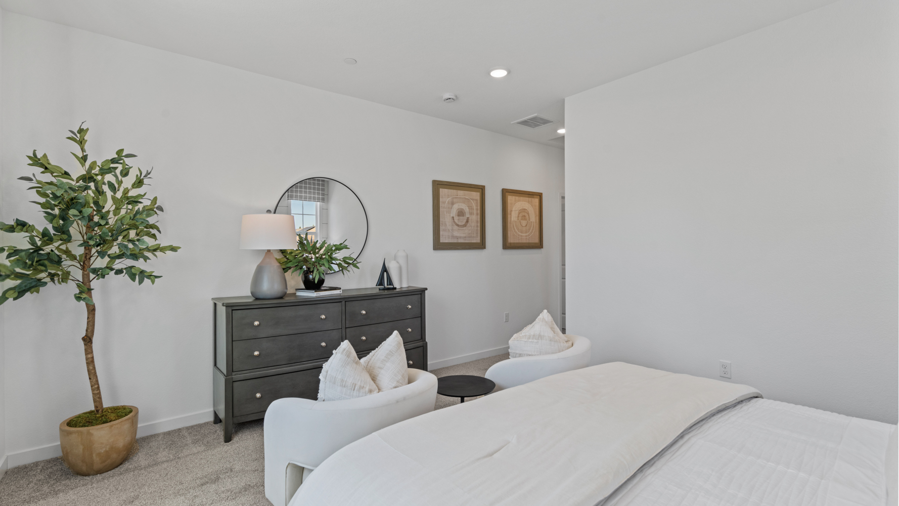 A bedroom with a bed and a plant.