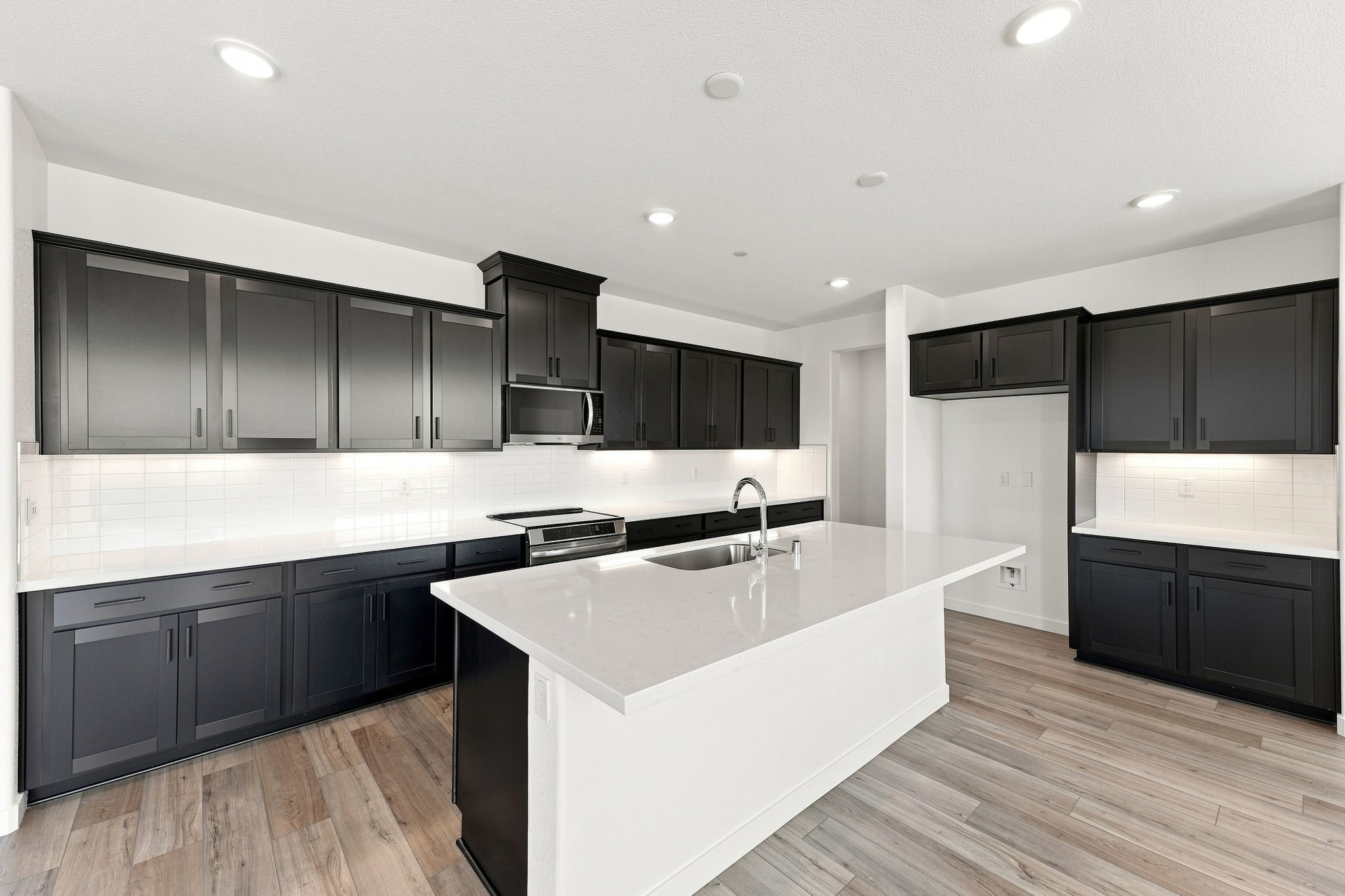 A kitchen with black cabinets.