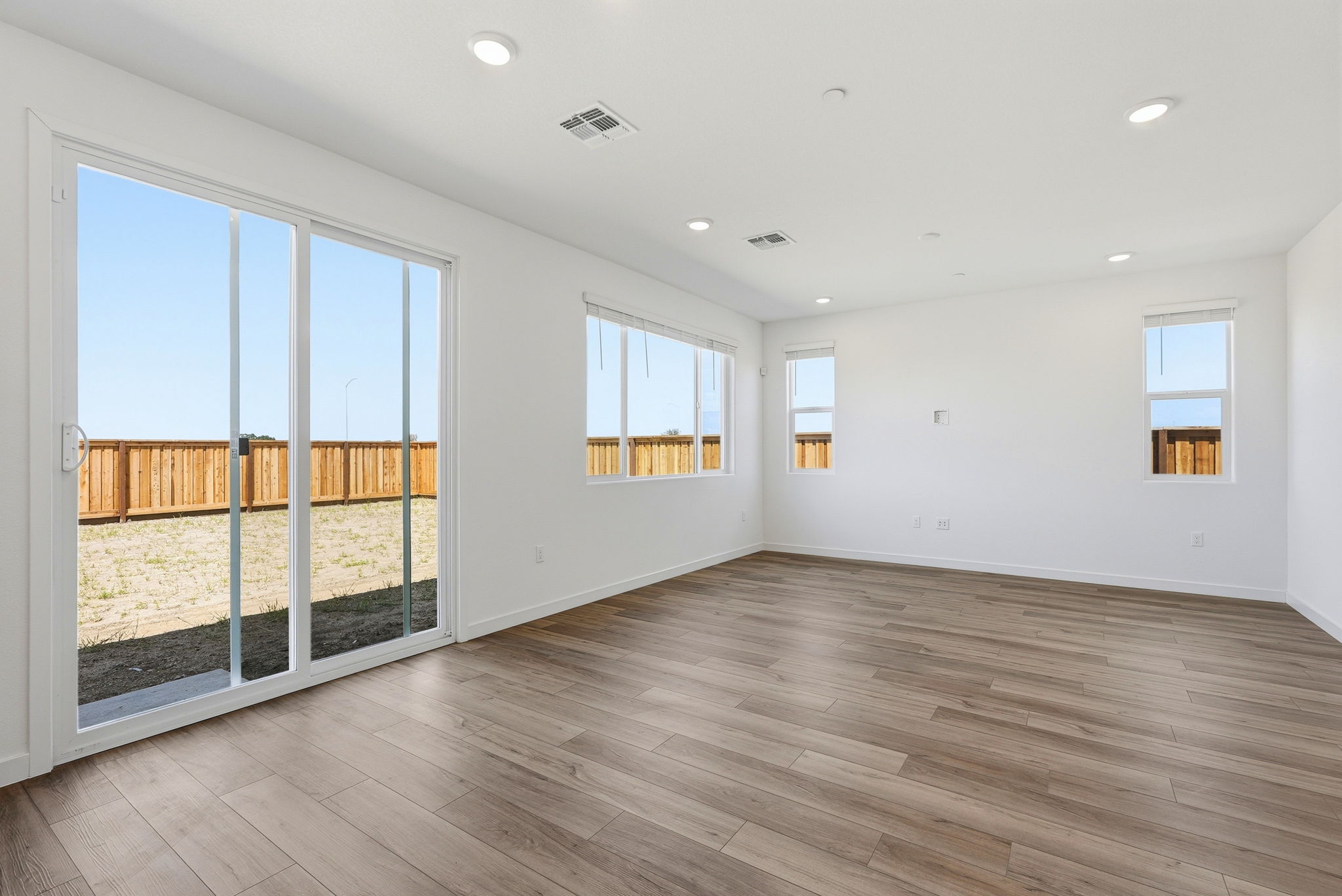 A room with a wood floor and windows.
